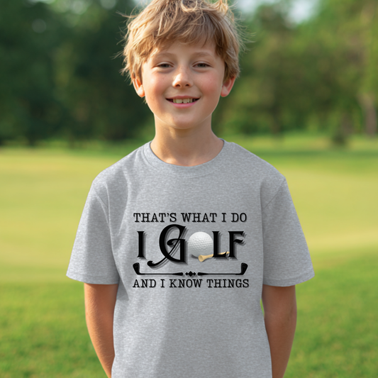Child wearing a gray t-shirt with a golf-themed design outdoors.