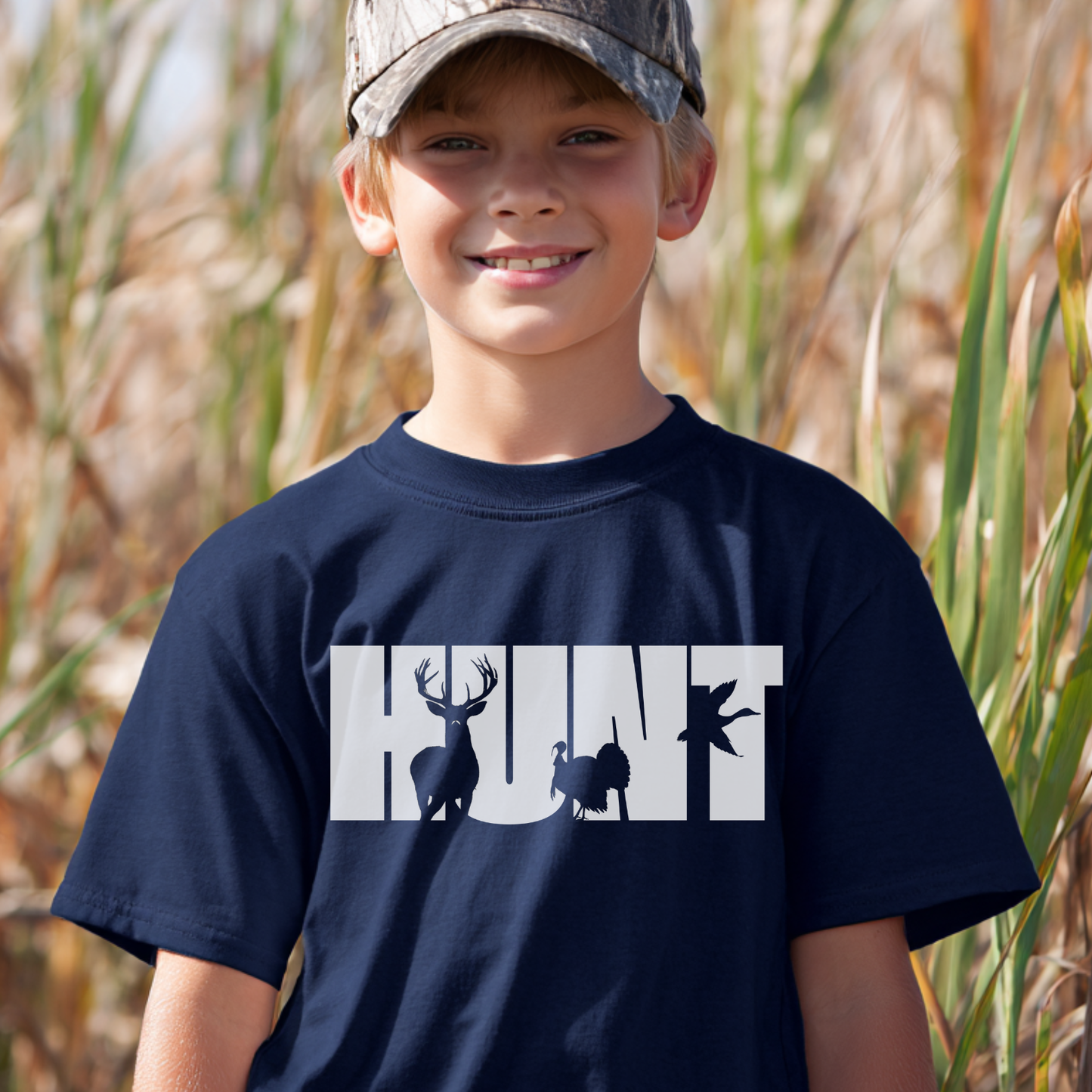 Child wearing a navy blue t-shirt with 'HUNT' graphic in an outdoor setting