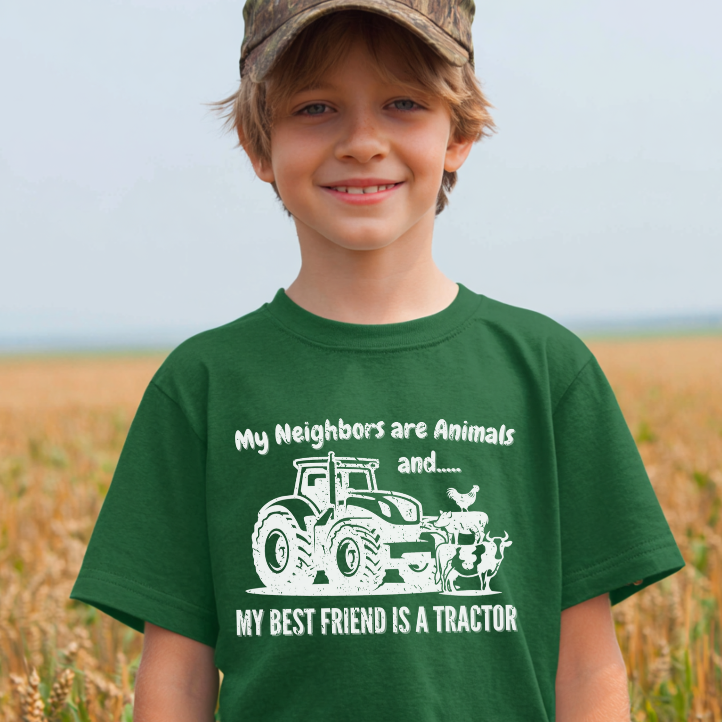 Child wearing a green t-shirt with a tractor graphic and text in a field