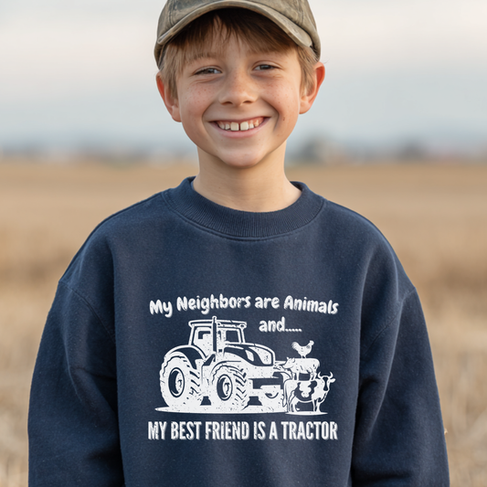 Child wearing a navy blue sweatshirt with a tractor graphic and text in an outdoor setting