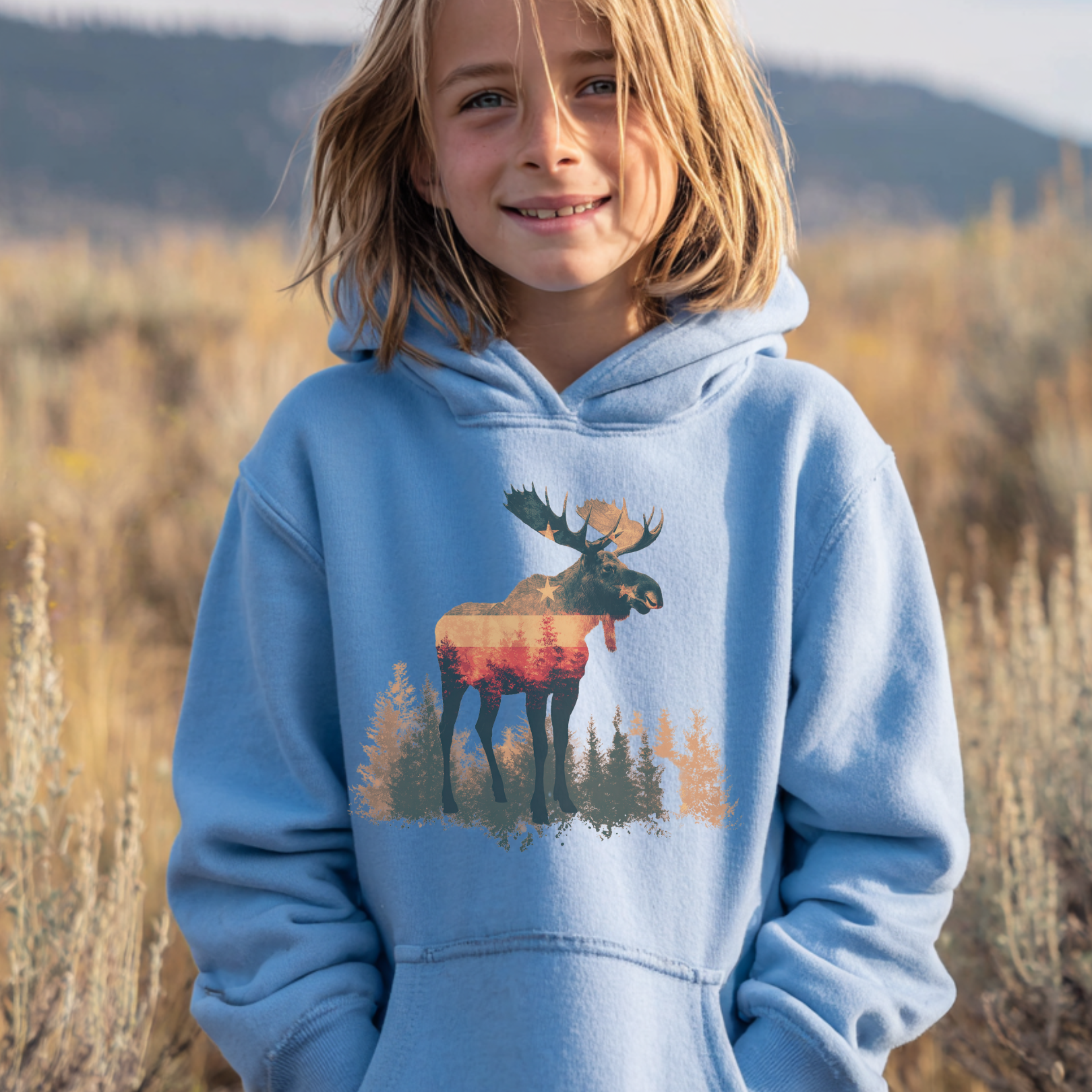Child wearing a blue hoodie with a moose design in a natural setting