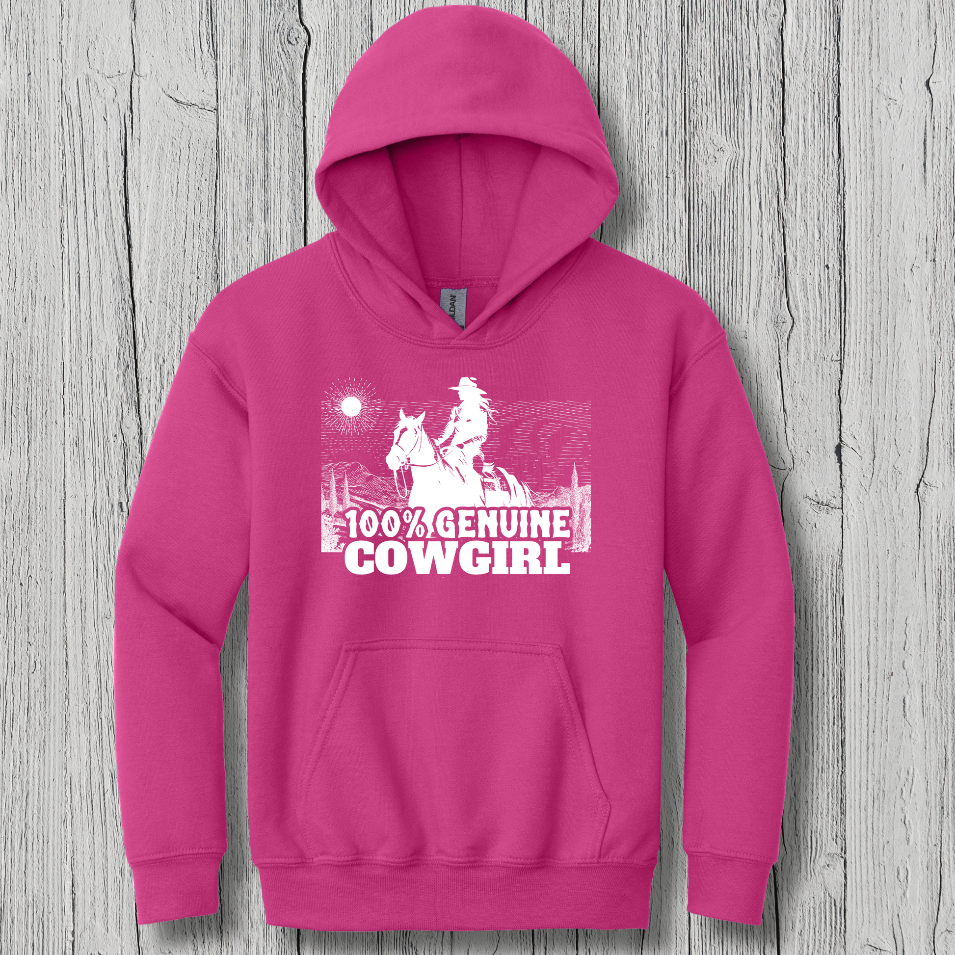 Pink hoodie with '100% Genuine Cowgirl' graphic on a wooden surface