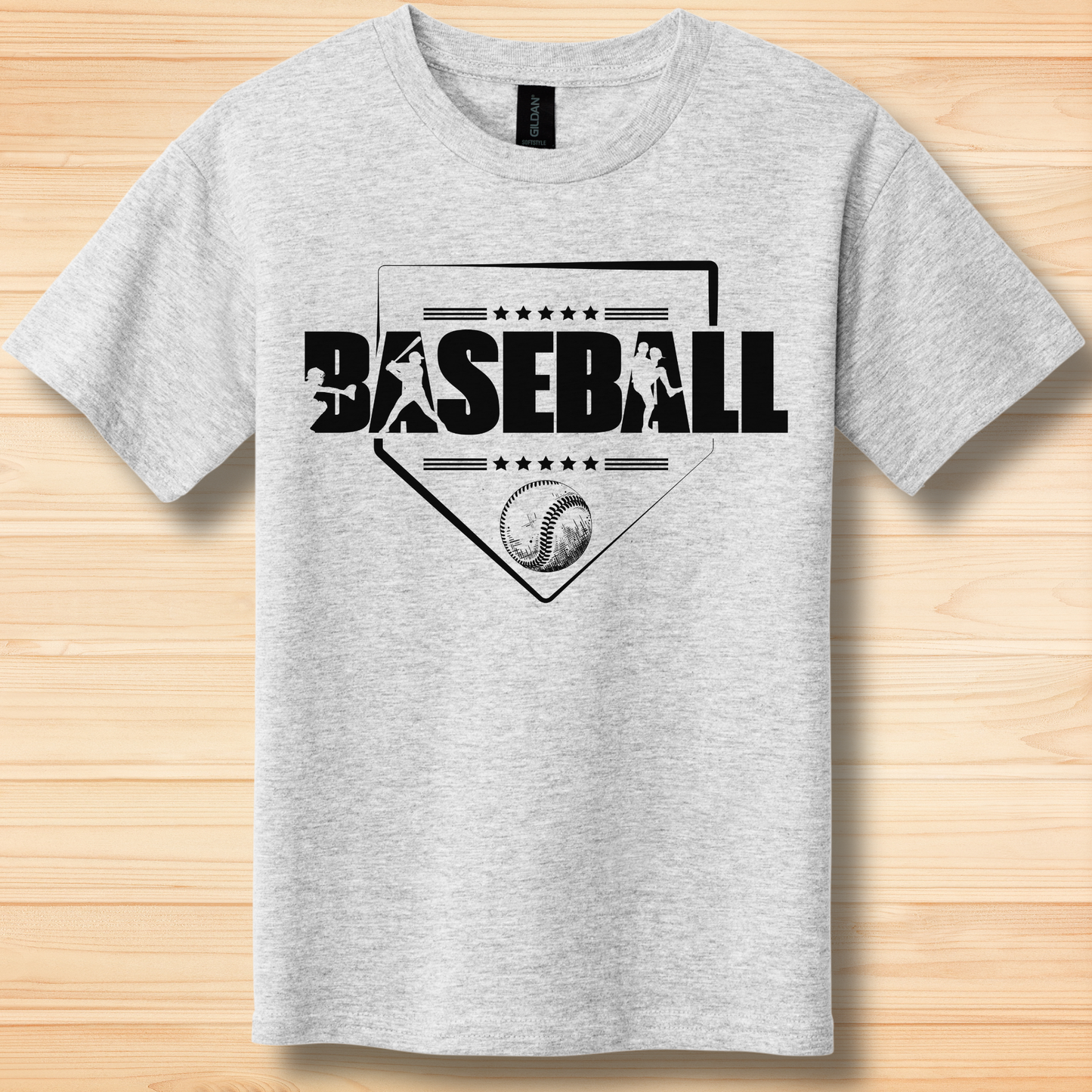 Gray t-shirt with black baseball graphic and text on a wooden surface