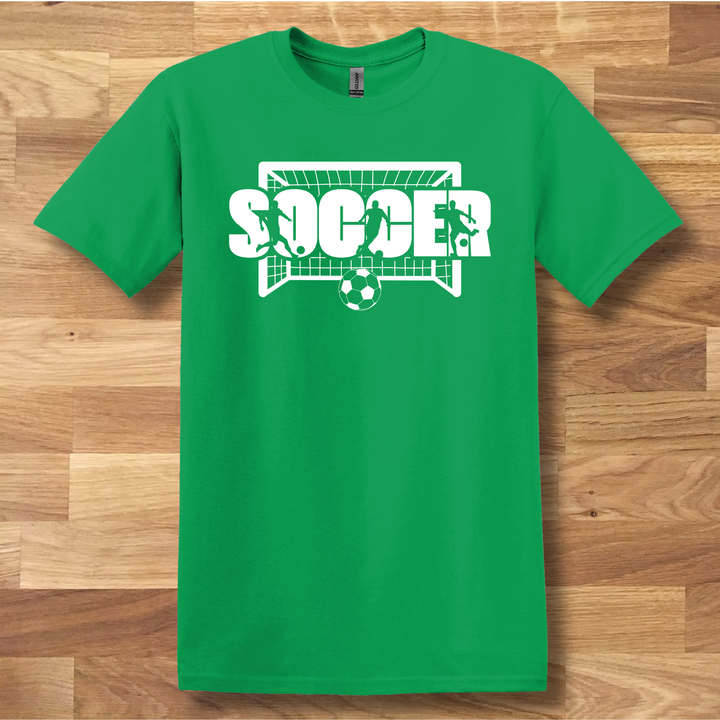 Green t-shirt with 'SOCCER' graphic on a wooden surface