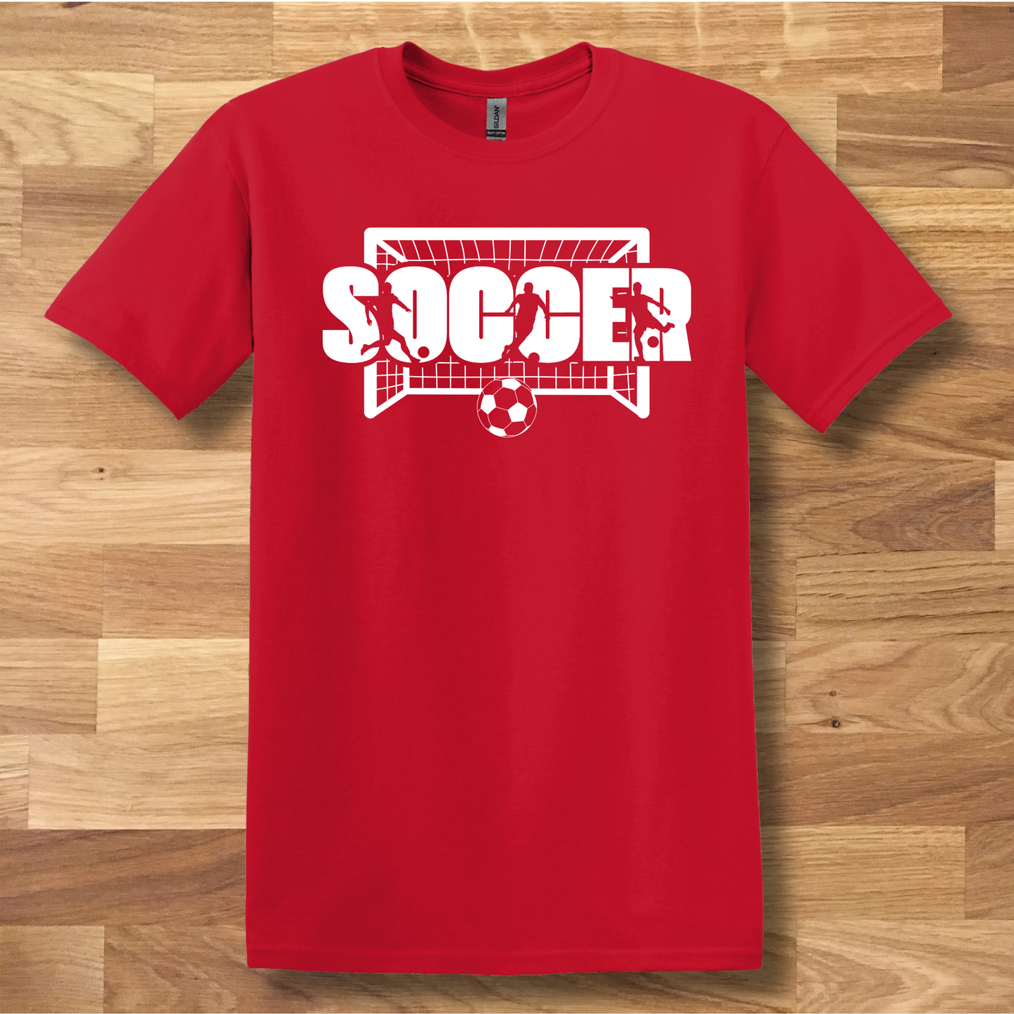 Red t-shirt with 'SOCCER' graphic on a wooden surface