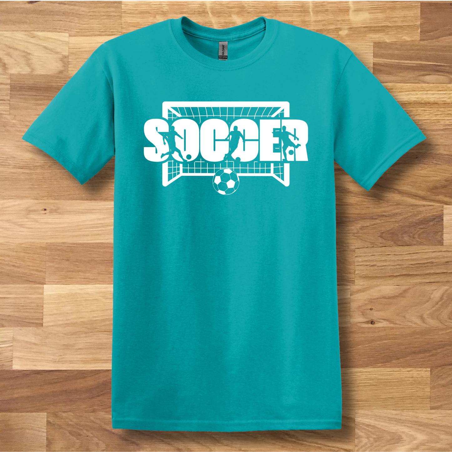 Teal t-shirt with soccer graphic on a wooden floor