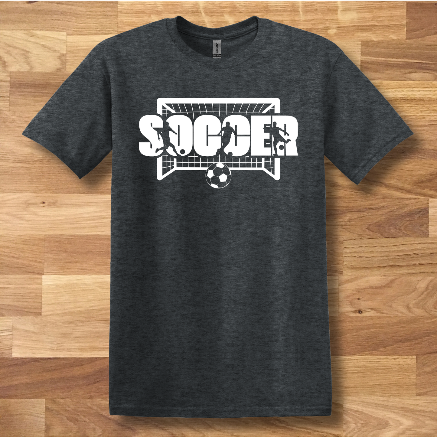 Dark gray t-shirt with soccer graphic on a wooden floor