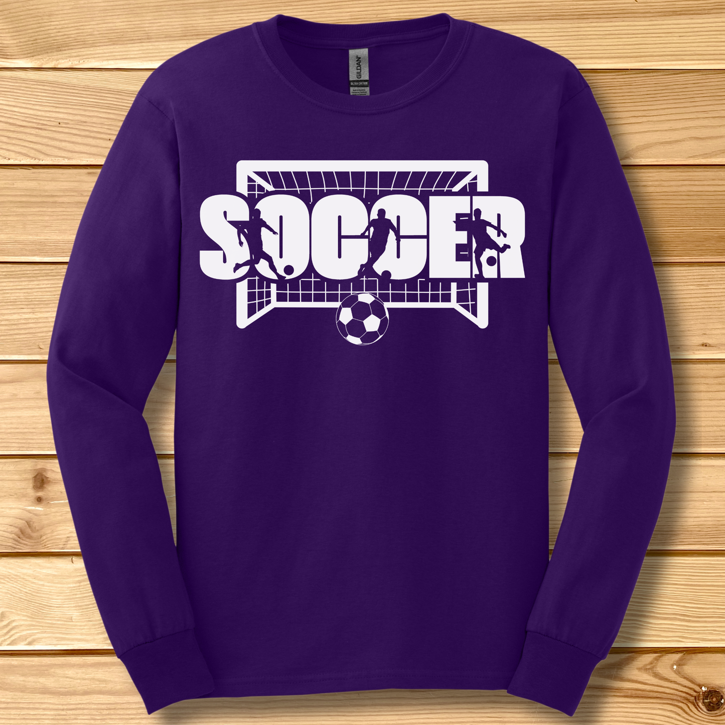 Purple long-sleeve shirt with soccer graphic on a wooden background