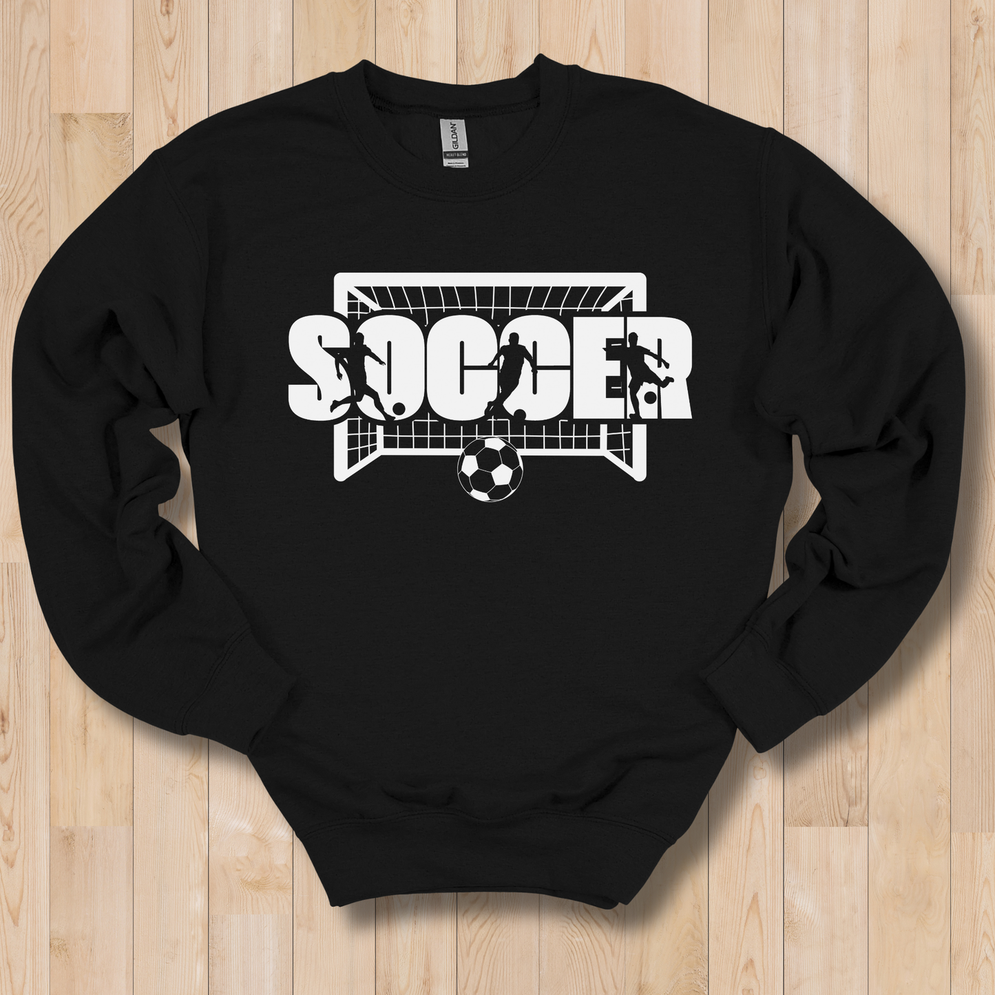 Black sweatshirt with soccer graphic and text on a wooden surface