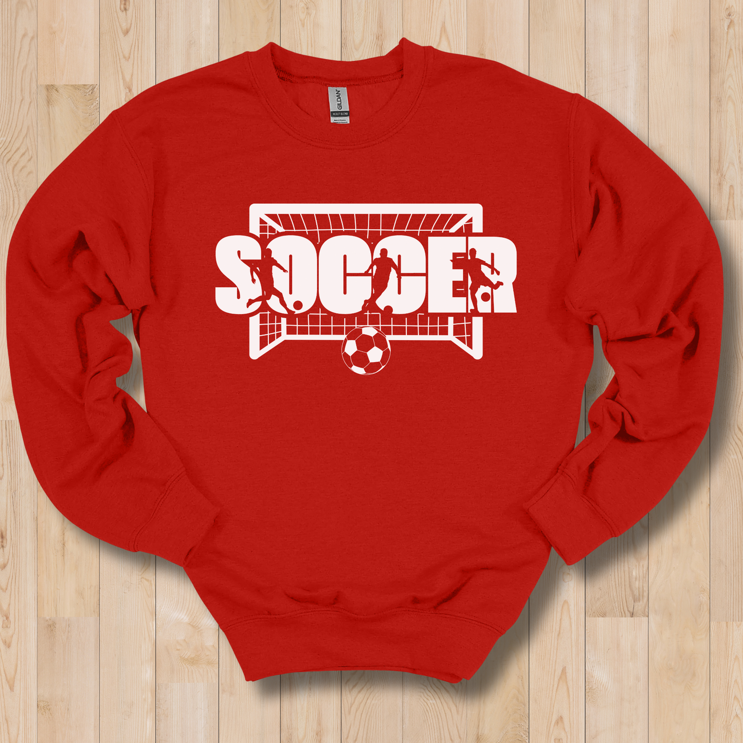 Red sweatshirt with 'Soccer' graphic on a wooden surface
