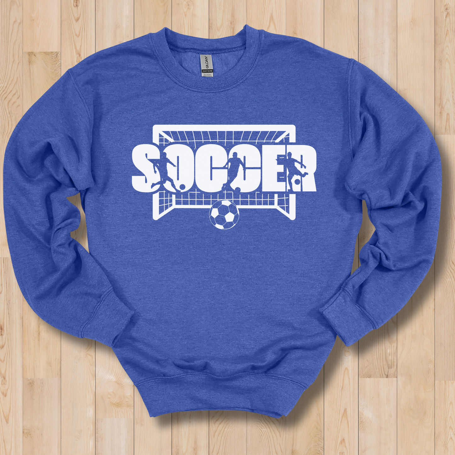 Blue sweatshirt with soccer graphic on a wooden surface