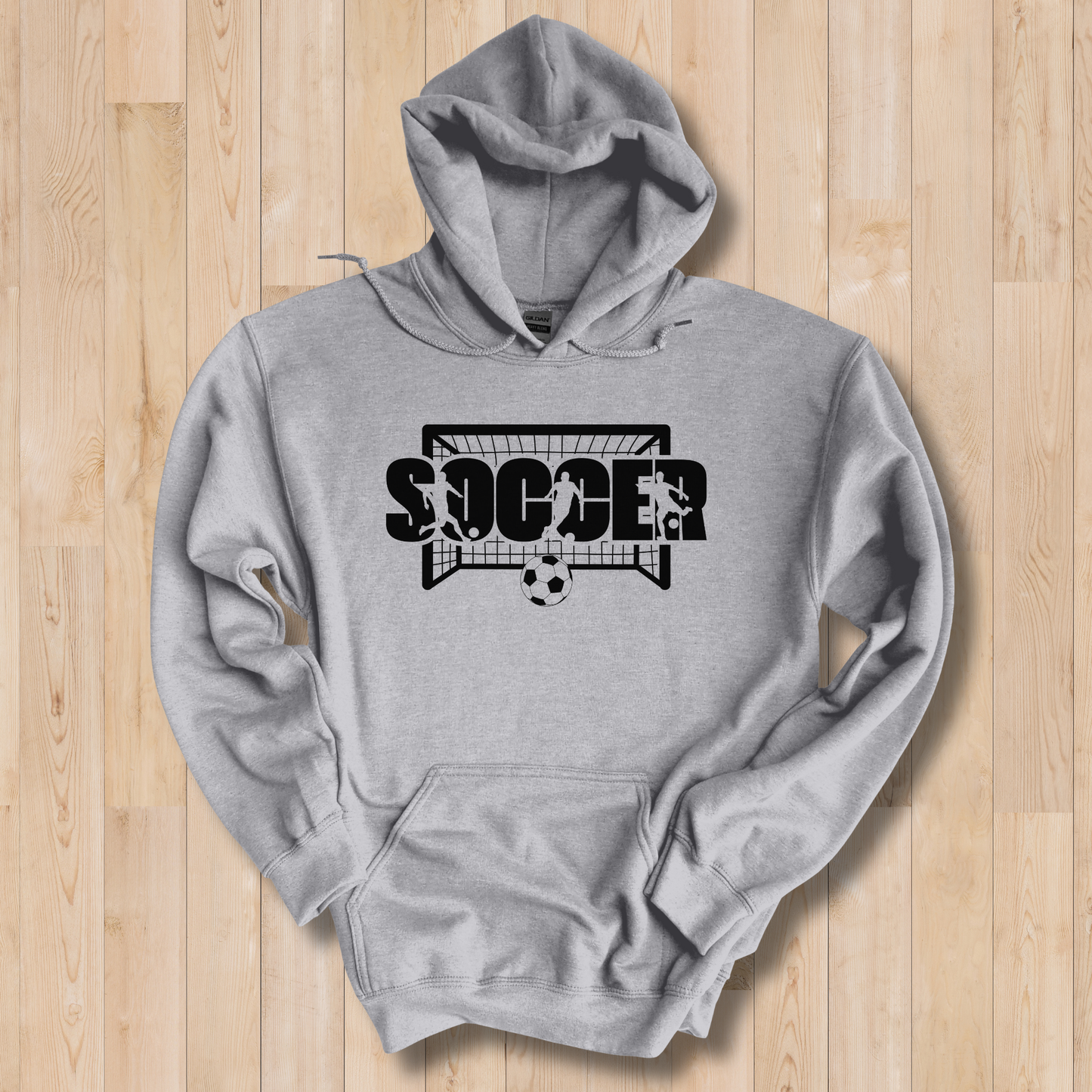 Gray hoodie with 'SOCCER' and soccer ball design on a wooden surface