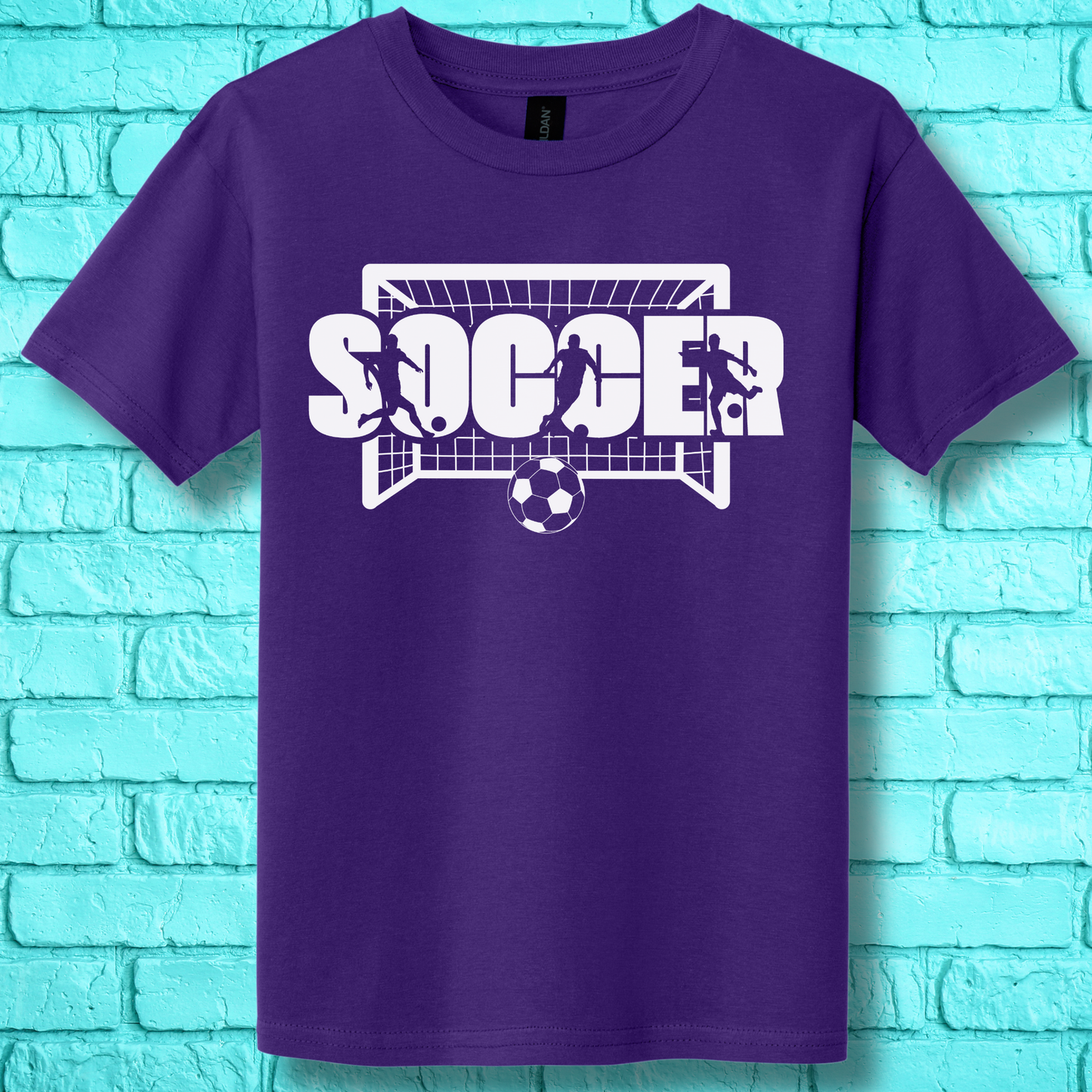 Purple t-shirt with soccer graphic and text on a turquoise brick wall background