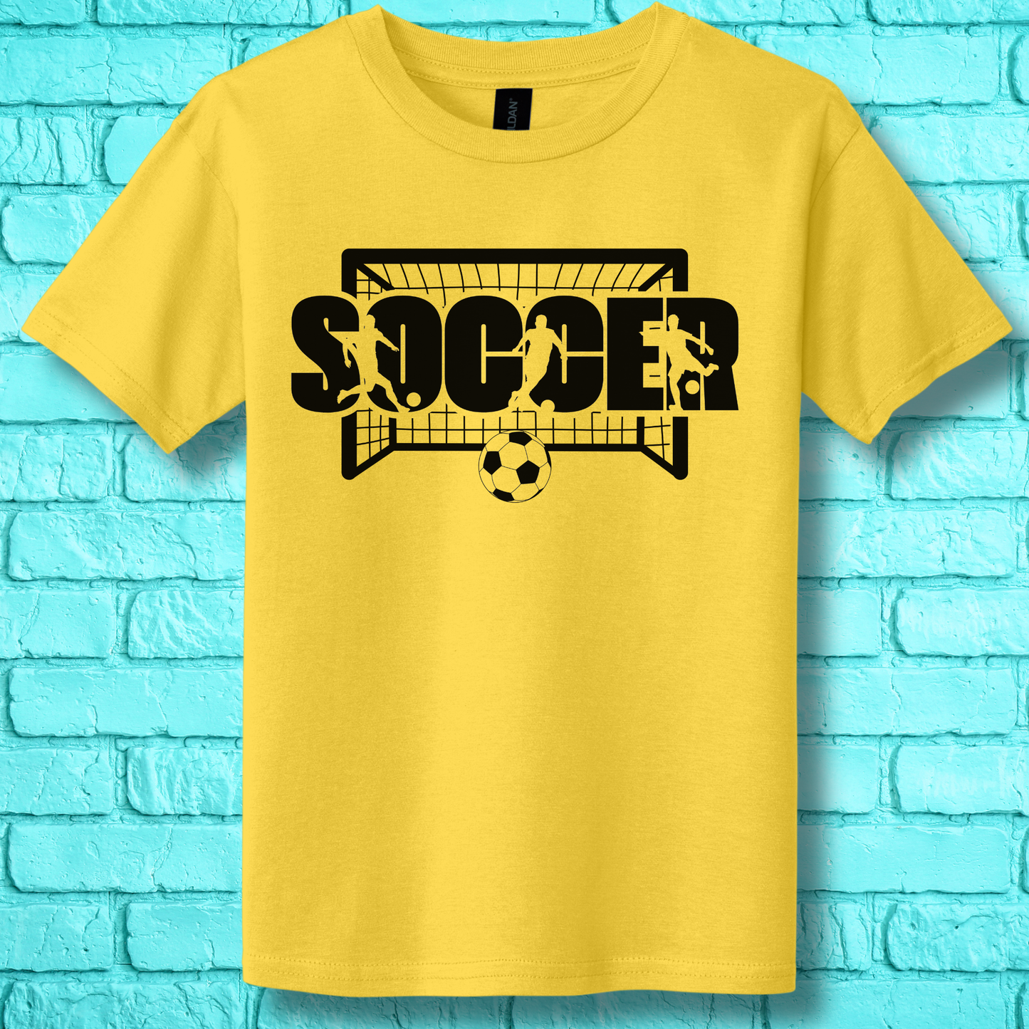 Yellow t-shirt with 'SOCCER' graphic design on a blue brick wall background