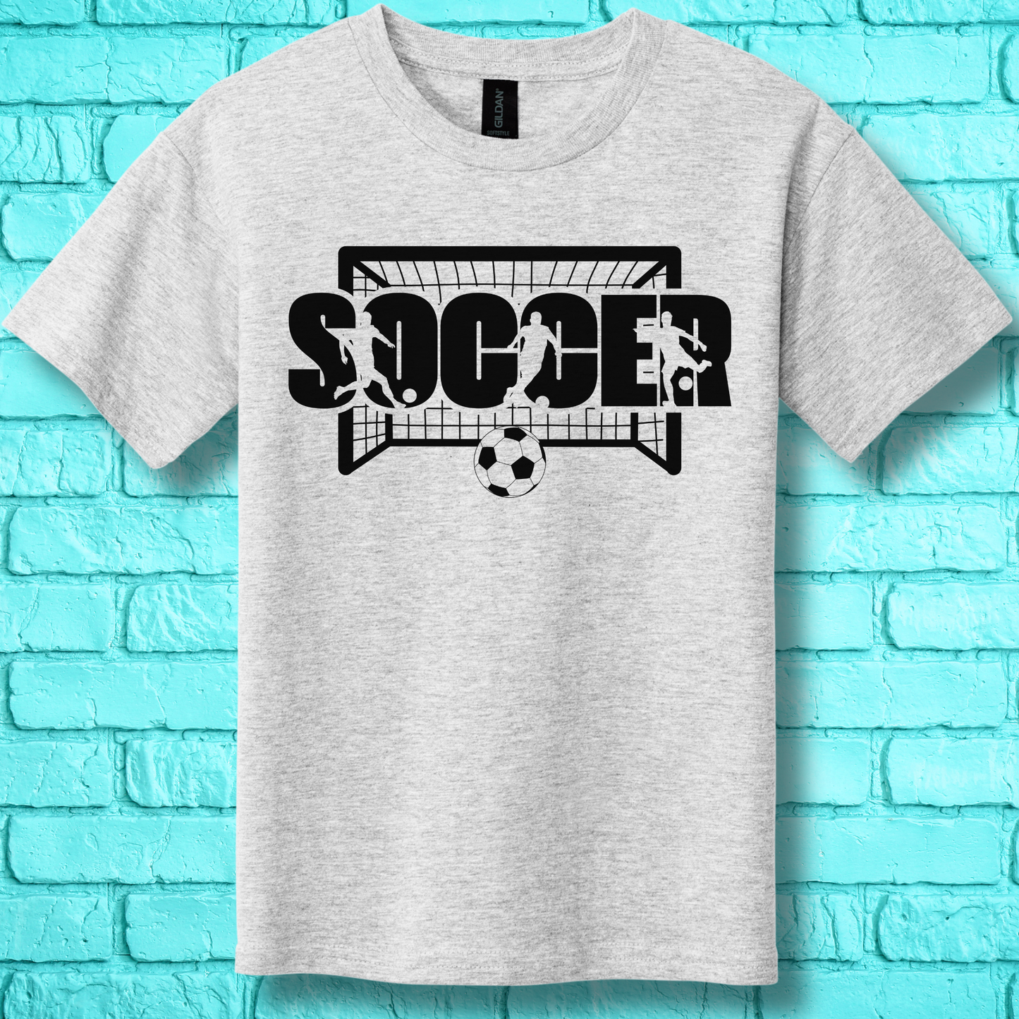 Gray t-shirt with soccer graphic design on a blue brick wall background