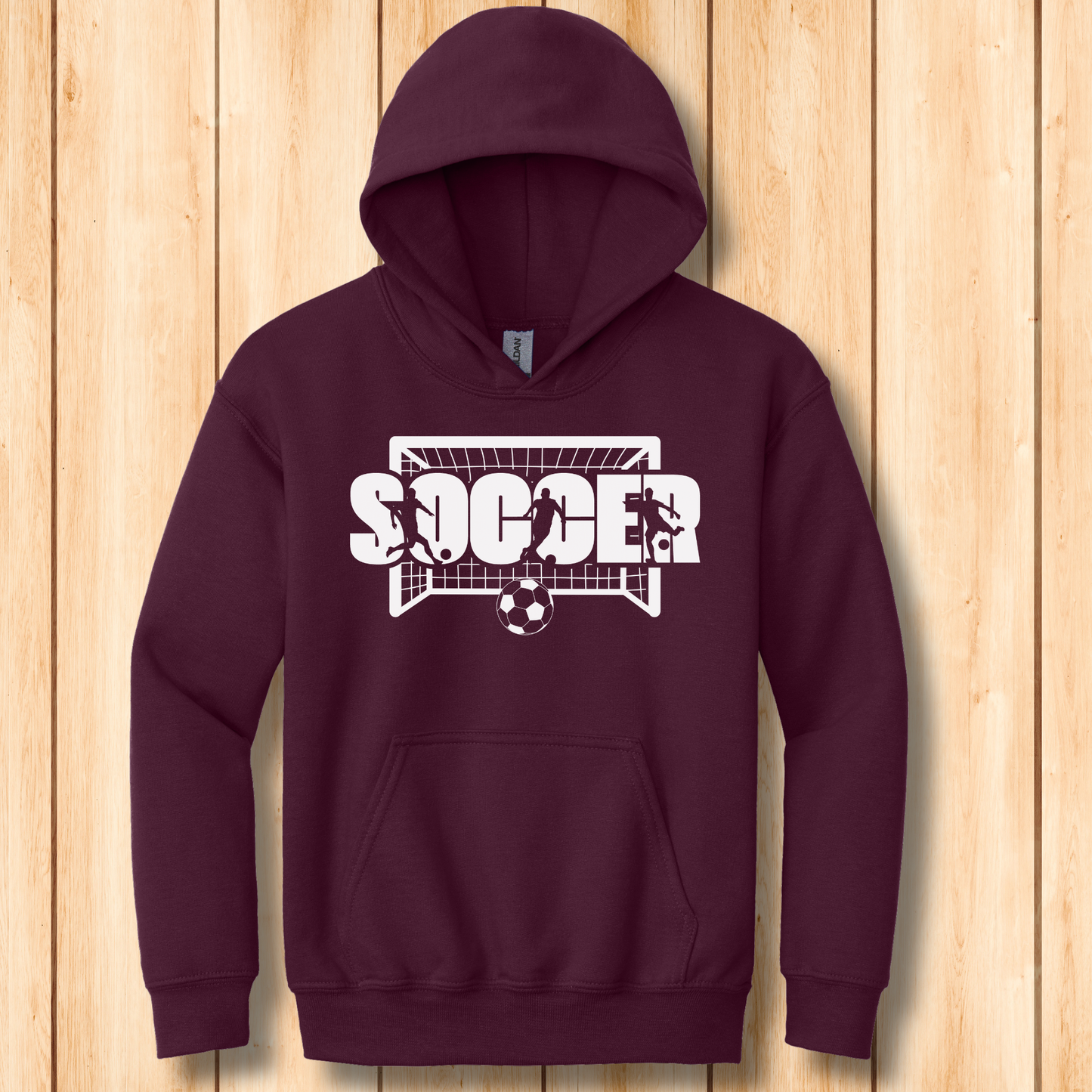 Maroon hoodie with soccer graphic on a wooden background