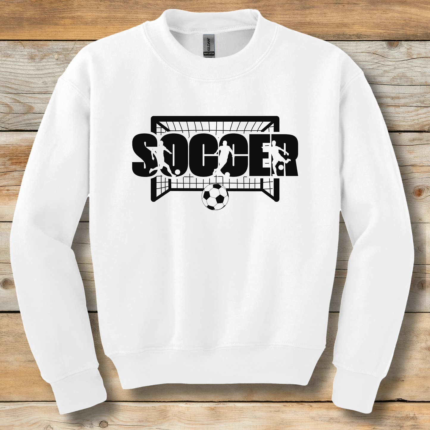 White sweatshirt with 'SOCCER' graphic on a wooden background
