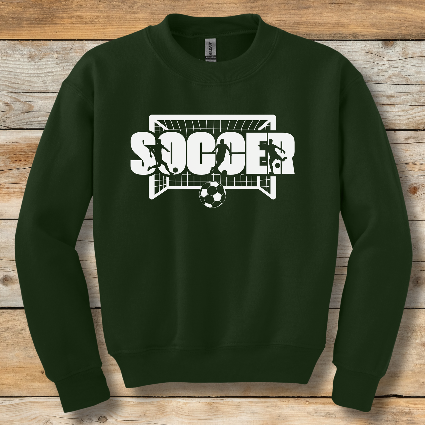 Green sweatshirt with 'SOCCER' graphic on a wooden surface