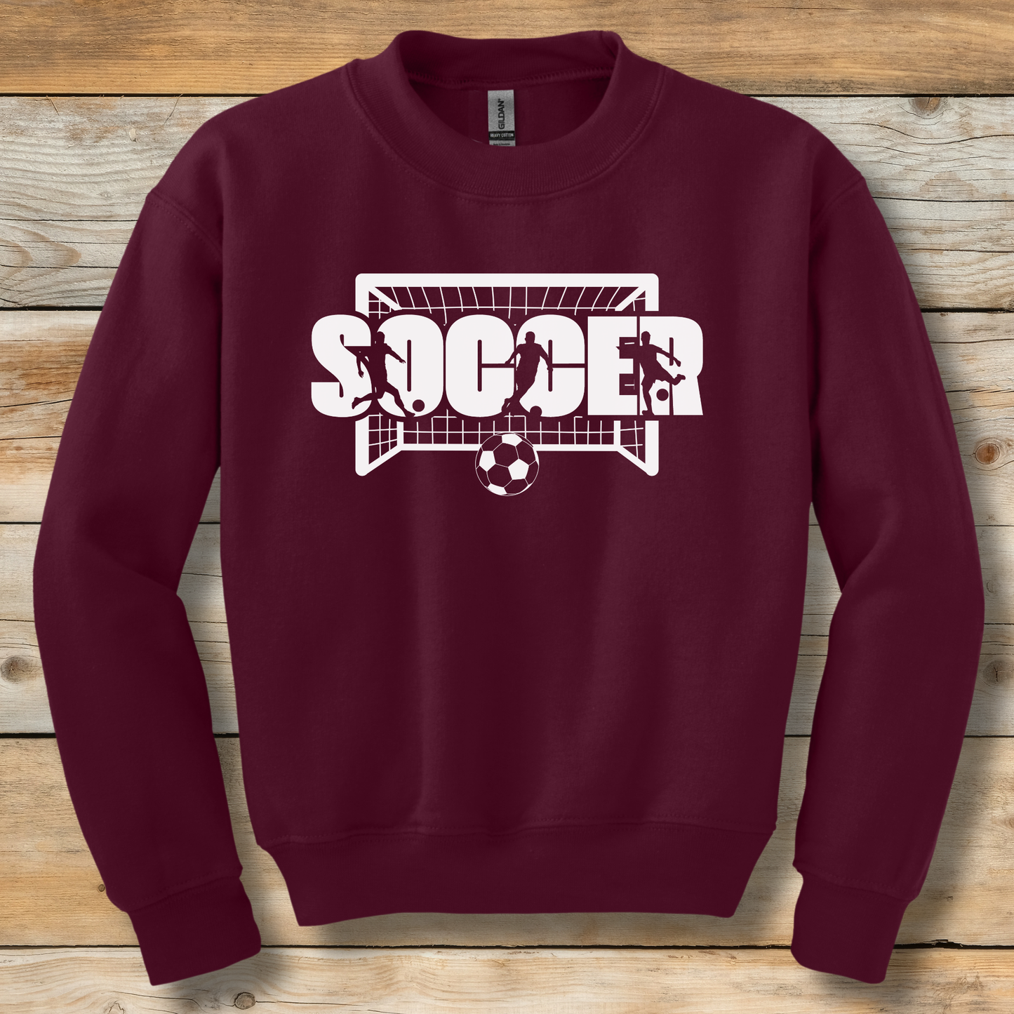 Maroon sweatshirt with 'SOCCER' graphic on a wooden background