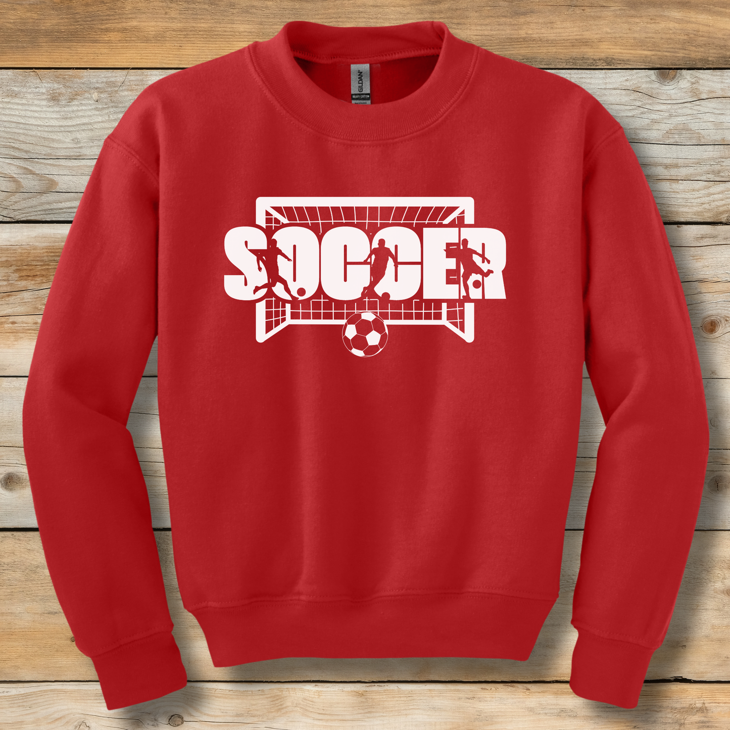 Red sweatshirt with 'SOCCER' graphic on a wooden background