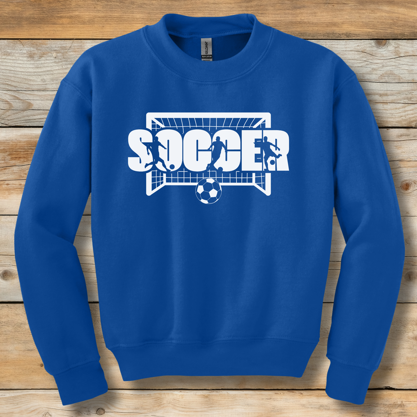 Blue sweatshirt with 'SOCCER' graphic on a wooden background