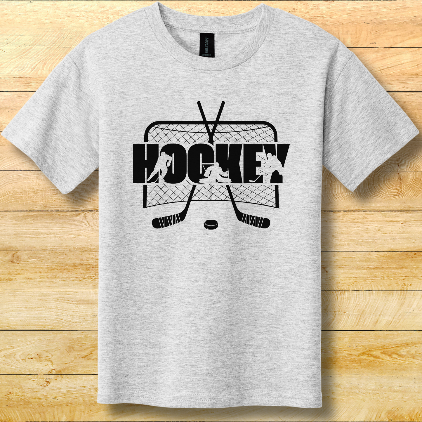 Gray t-shirt with hockey graphic design on a wooden surface