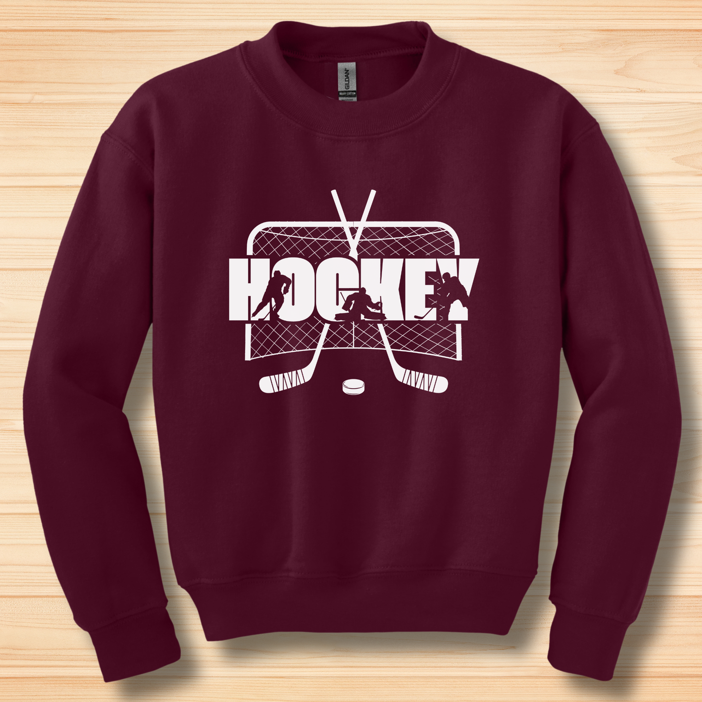 Maroon sweatshirt with hockey graphic on a wooden surface