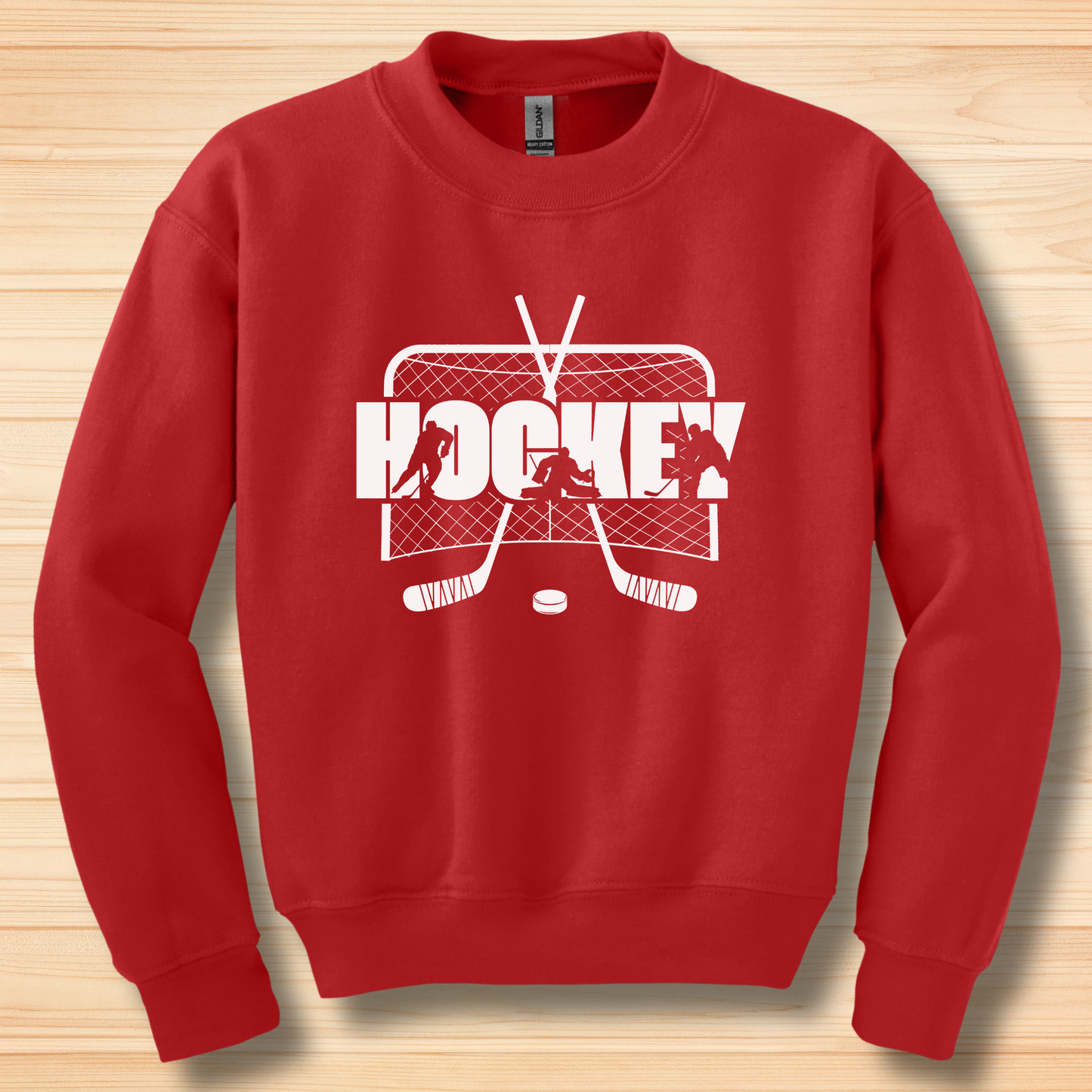 Red sweatshirt with white hockey graphic on a wooden surface