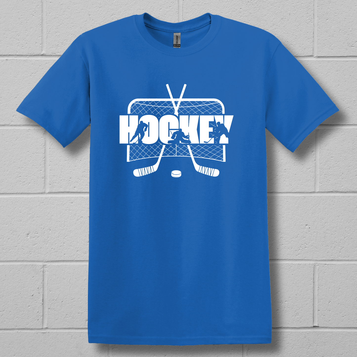 Blue t-shirt with white hockey graphic and text on a gray brick wall background