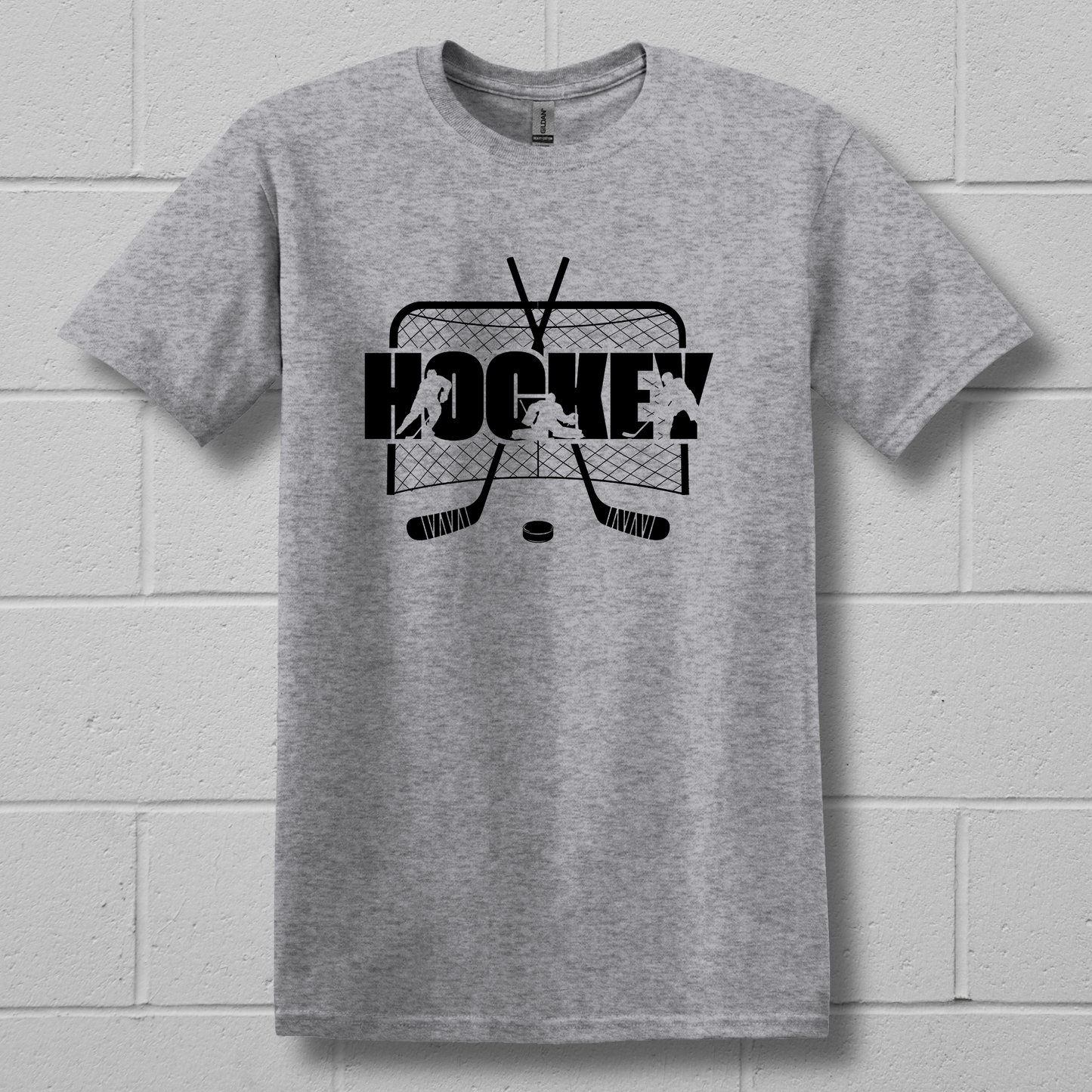 Gray t-shirt with black hockey graphic on a white brick wall background