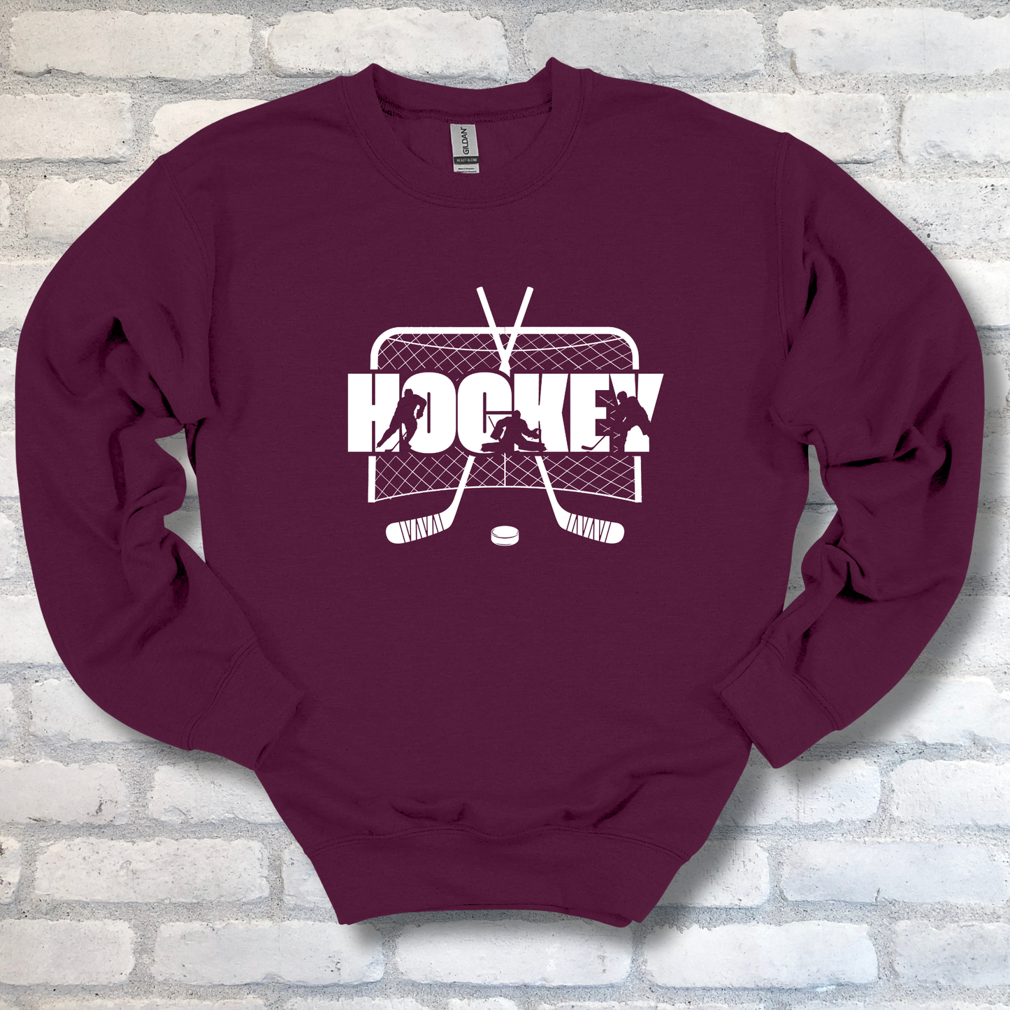 Maroon sweatshirt with hockey graphic on a brick wall background