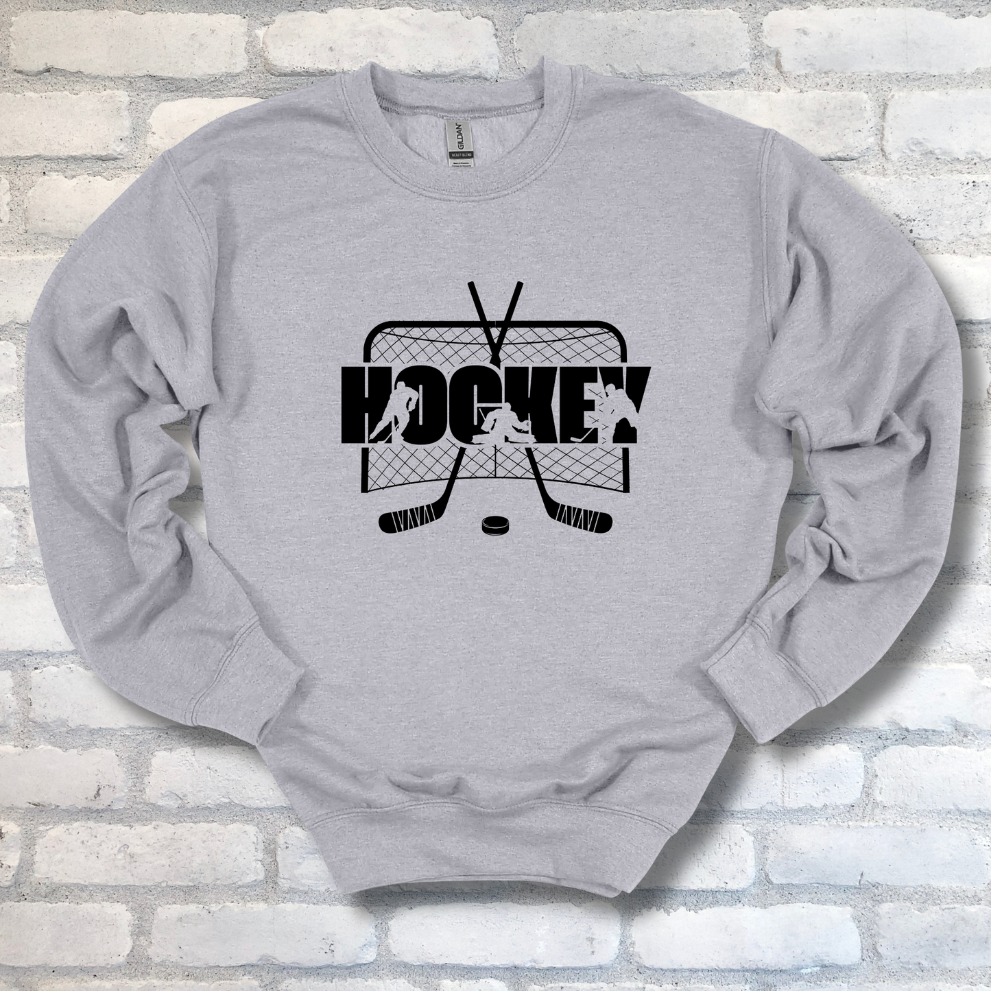 Gray sweatshirt with hockey graphic and text on a brick wall background
