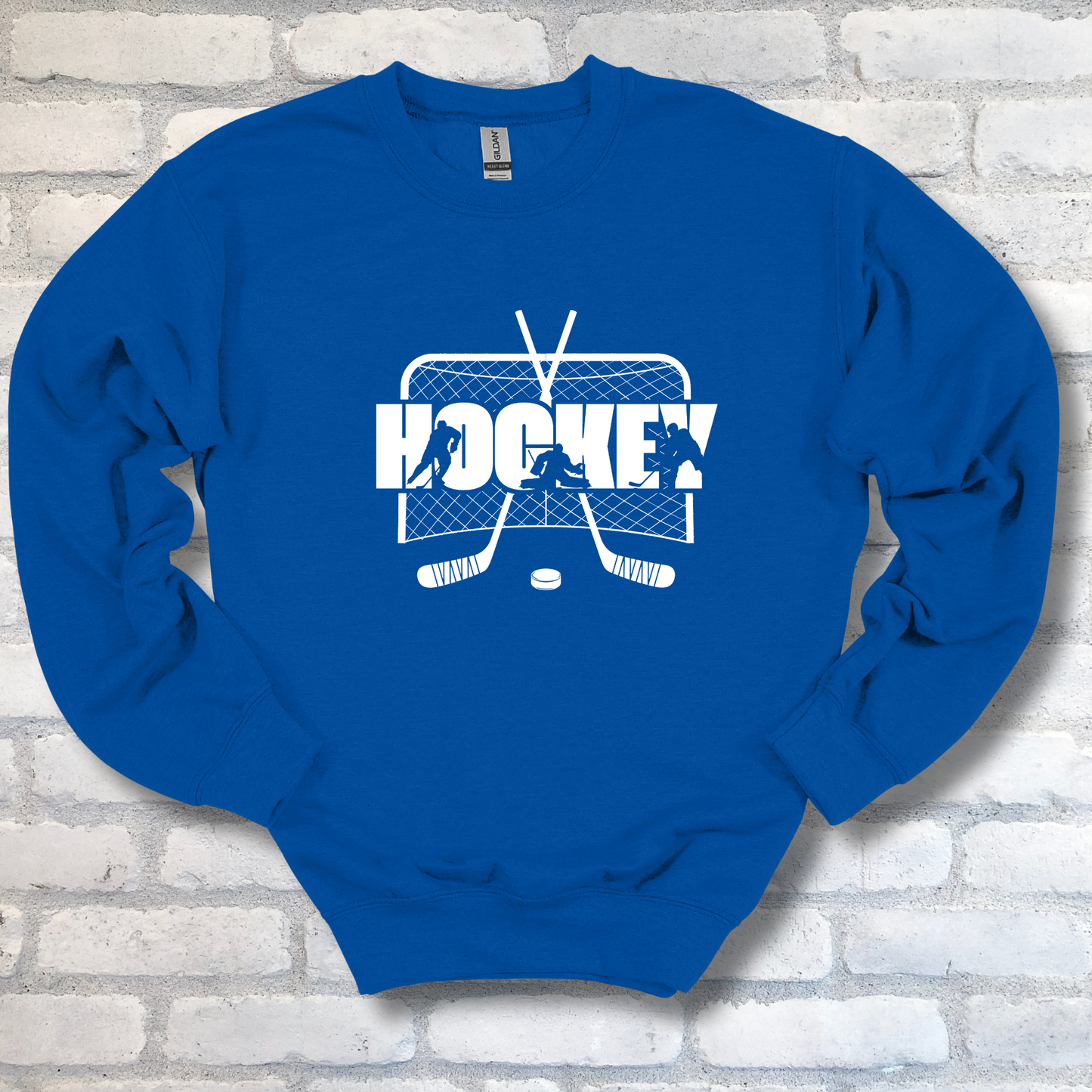 Blue sweatshirt with white hockey graphic and text on a brick wall background