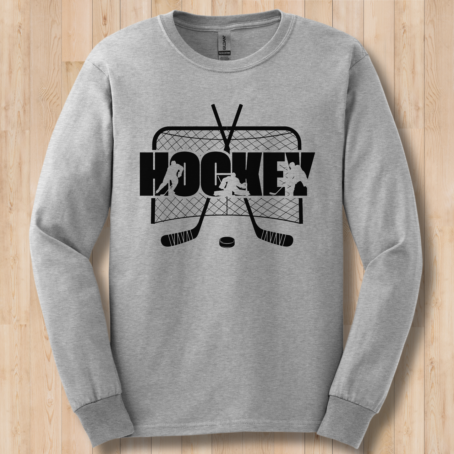 Gray long-sleeve shirt with black hockey graphic on a wooden surface
