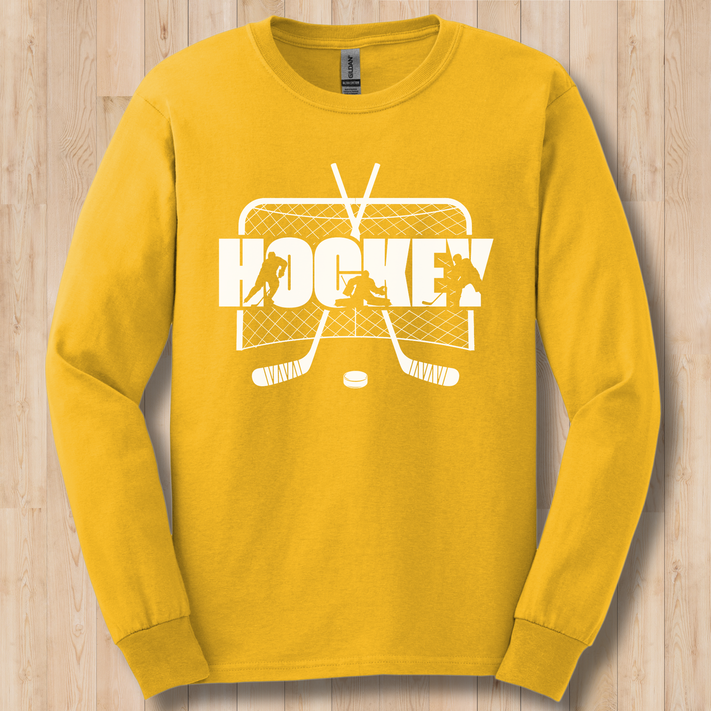 Yellow long-sleeve shirt with white hockey graphic on a wooden surface