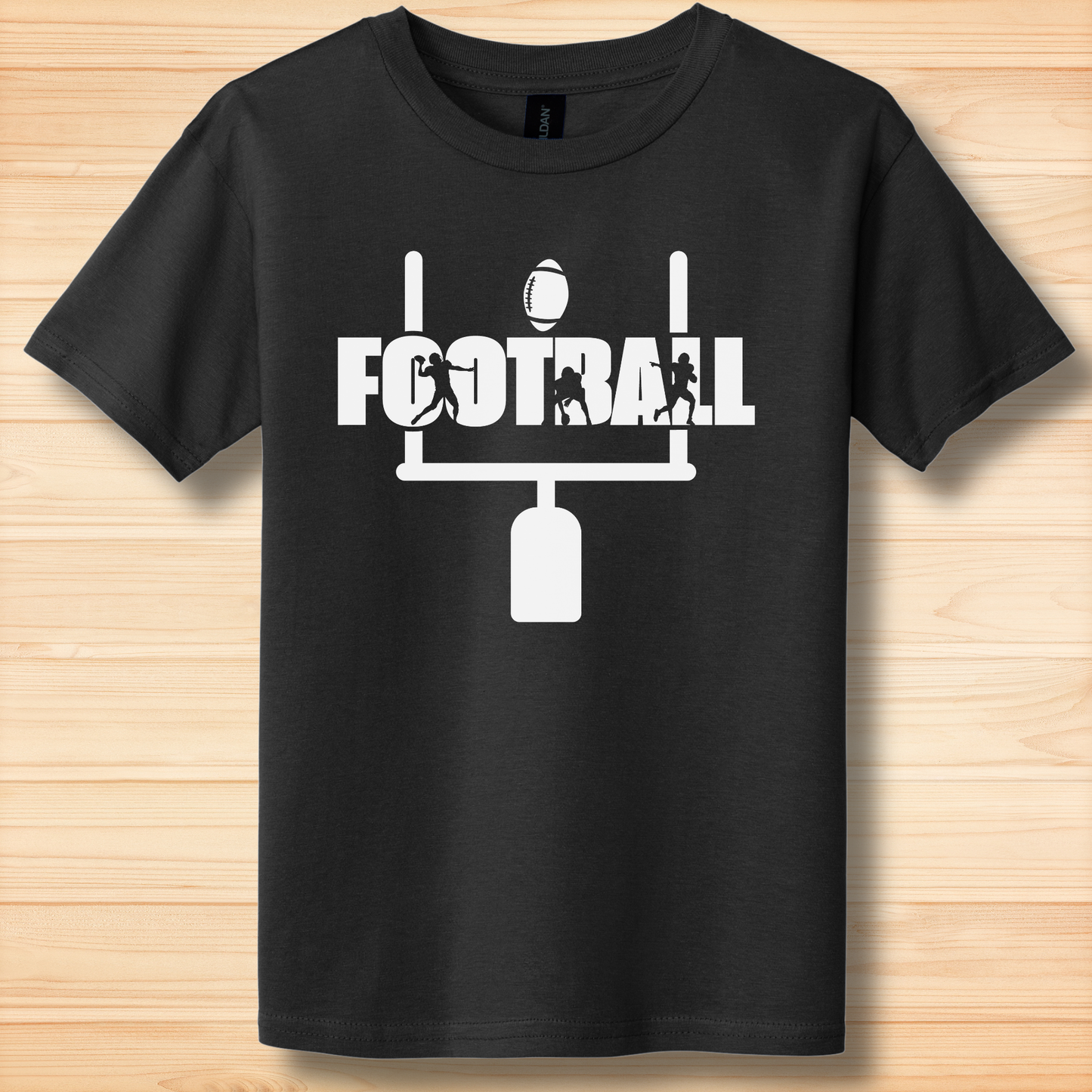 Black t-shirt with white football graphic and text on a wooden surface