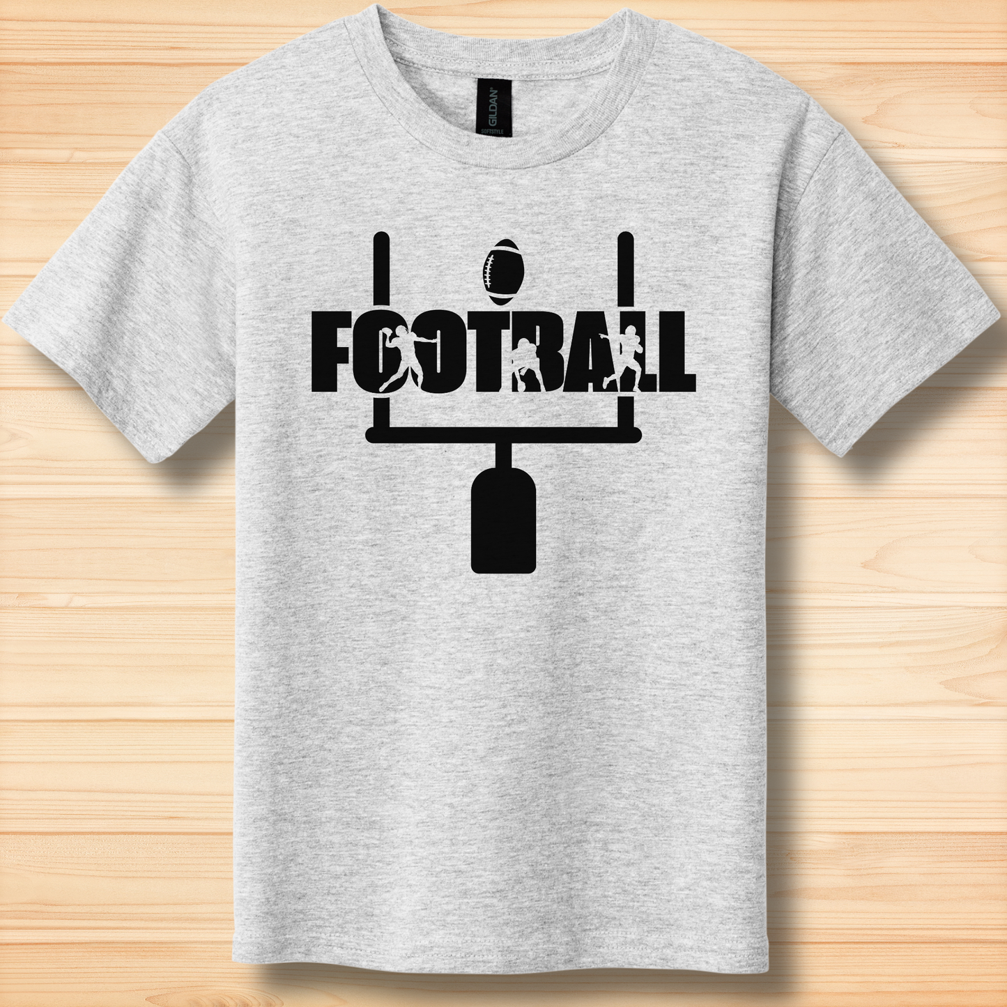 Gray t-shirt with black 'FOOTBALL' graphic on a wooden surface