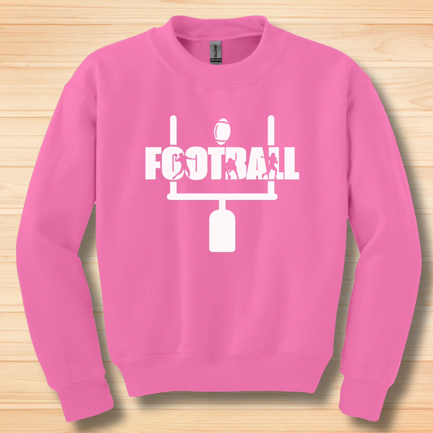Pink sweatshirt with football design on a wooden surface