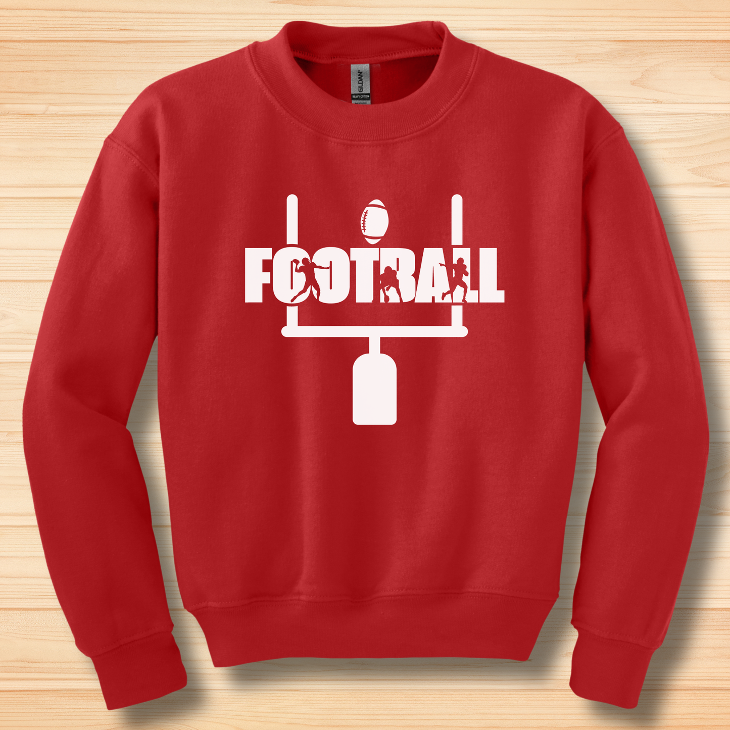 Red sweatshirt with white football graphics on a wooden surface
