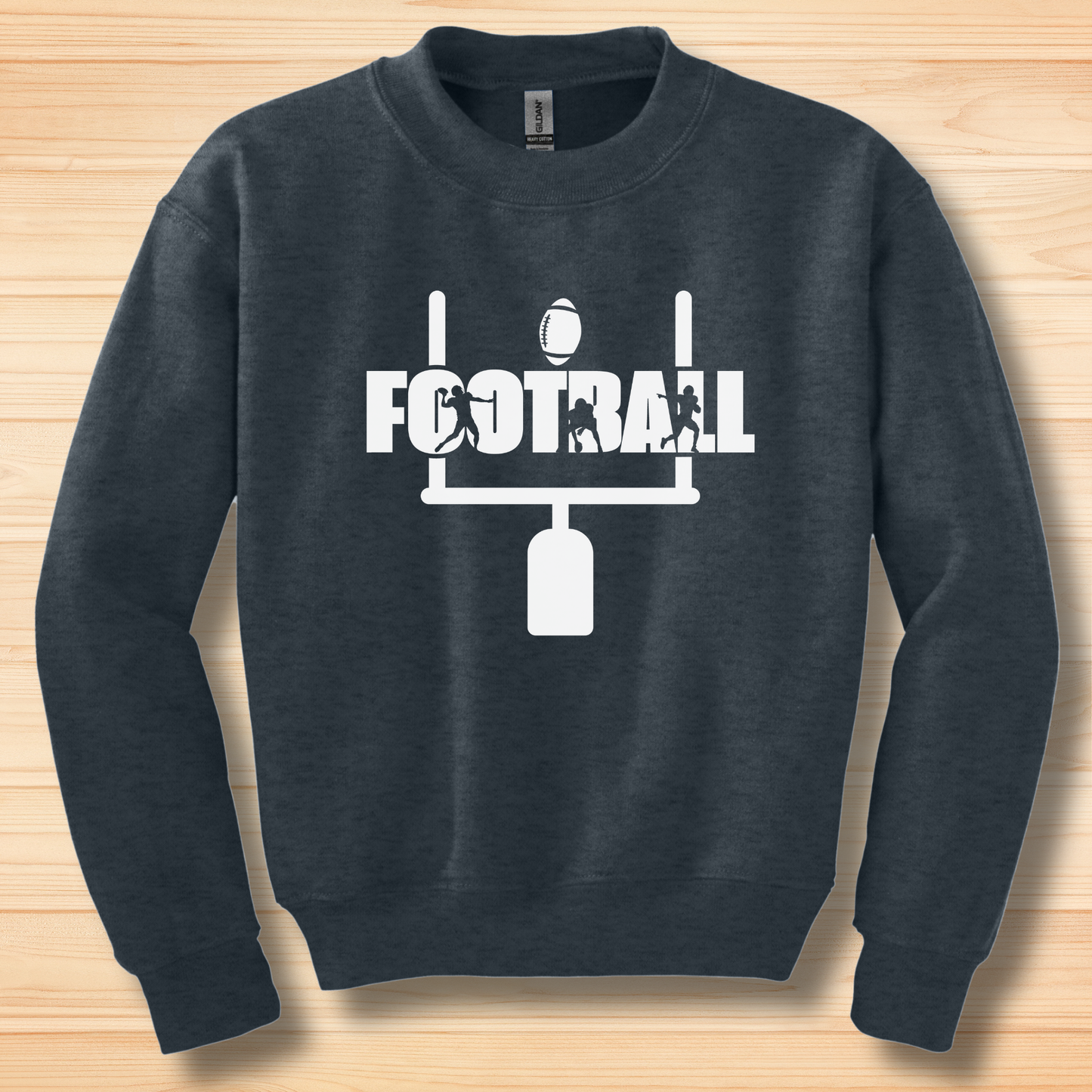 Navy blue sweatshirt with white football graphic and text on a wooden surface