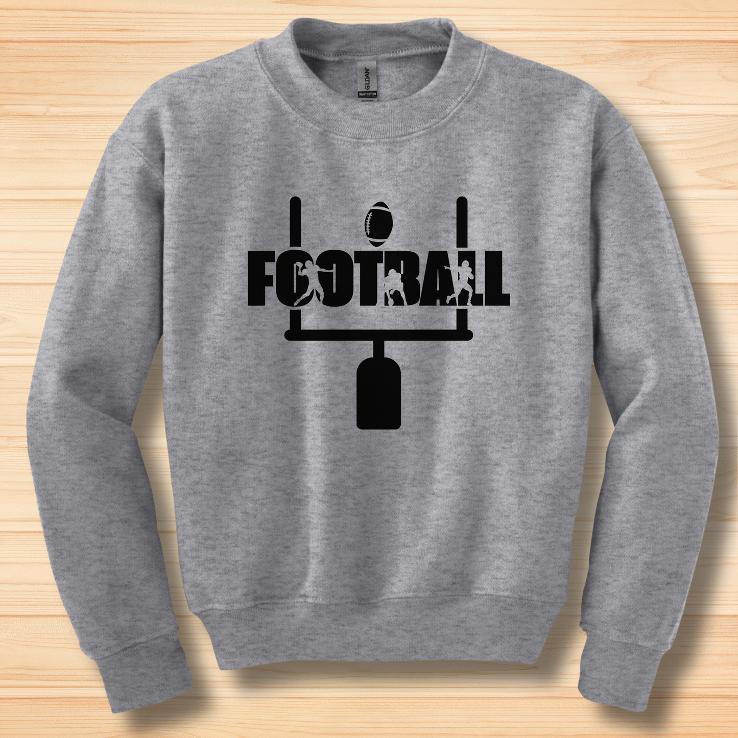 Gray sweatshirt with black 'FOOTBALL' graphic on a wooden surface