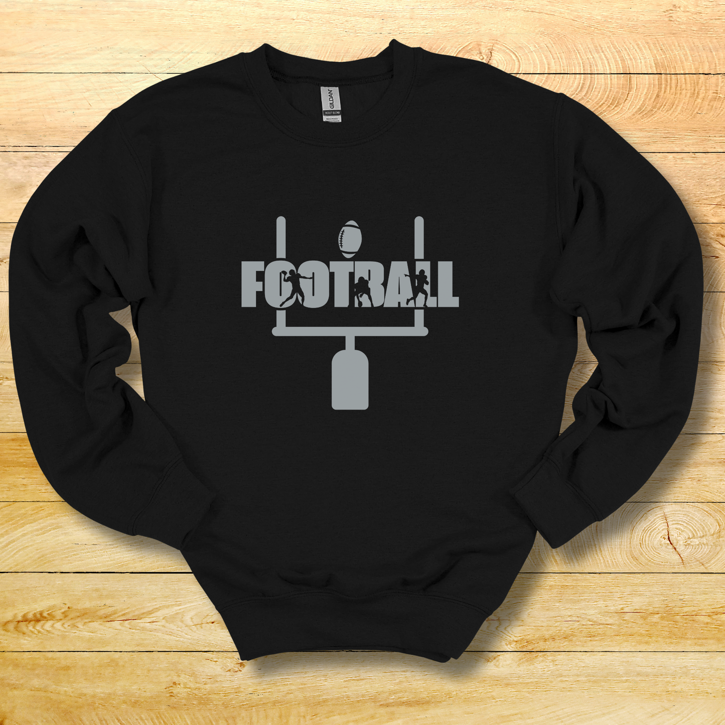 Black sweatshirt with 'FOOTBALL' graphic on a wooden surface