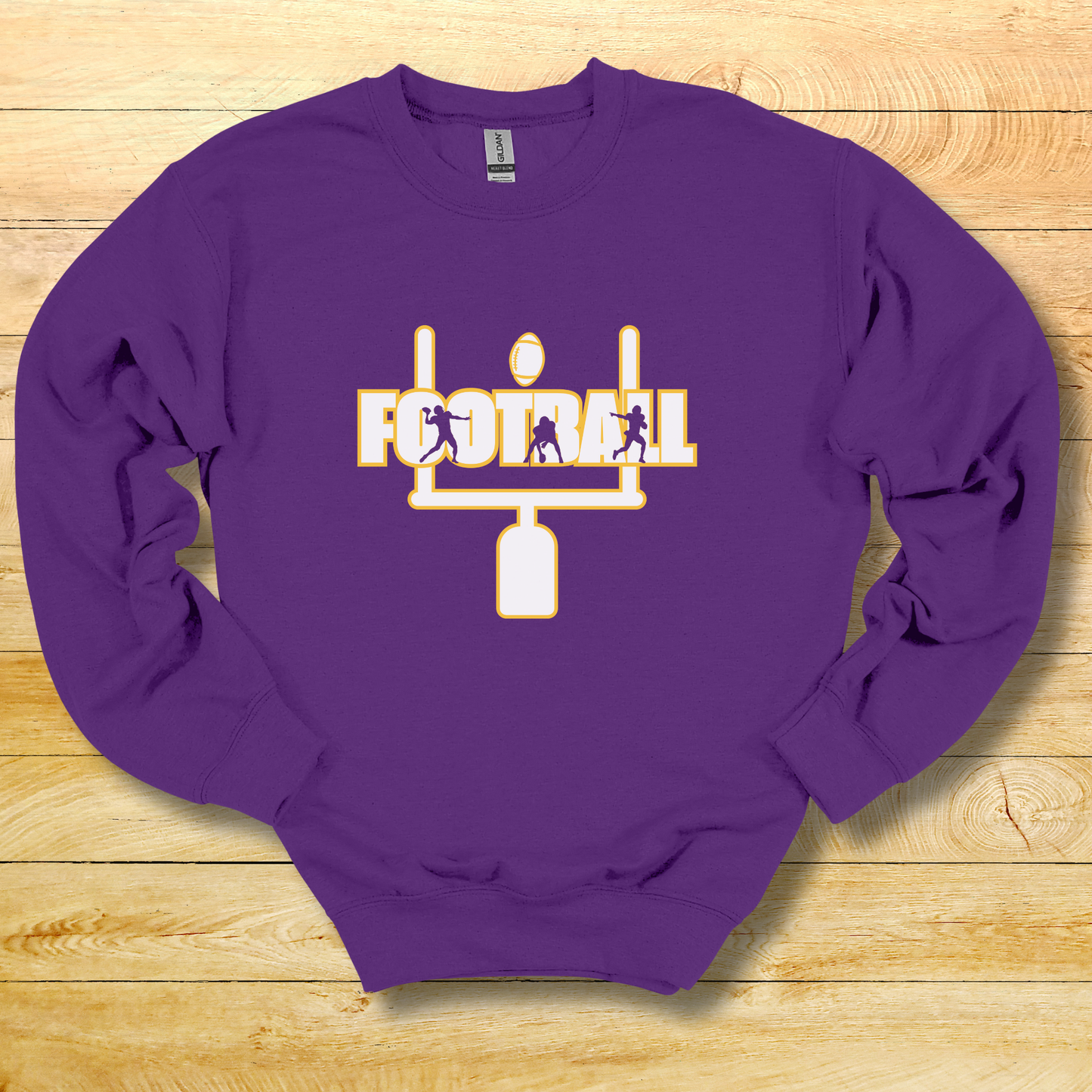 Purple sweatshirt with football graphic on a wooden surface