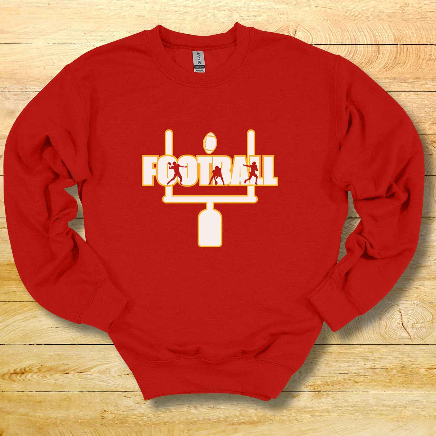 Red sweatshirt with football graphic and 'FOOTBALL' text on a wooden surface