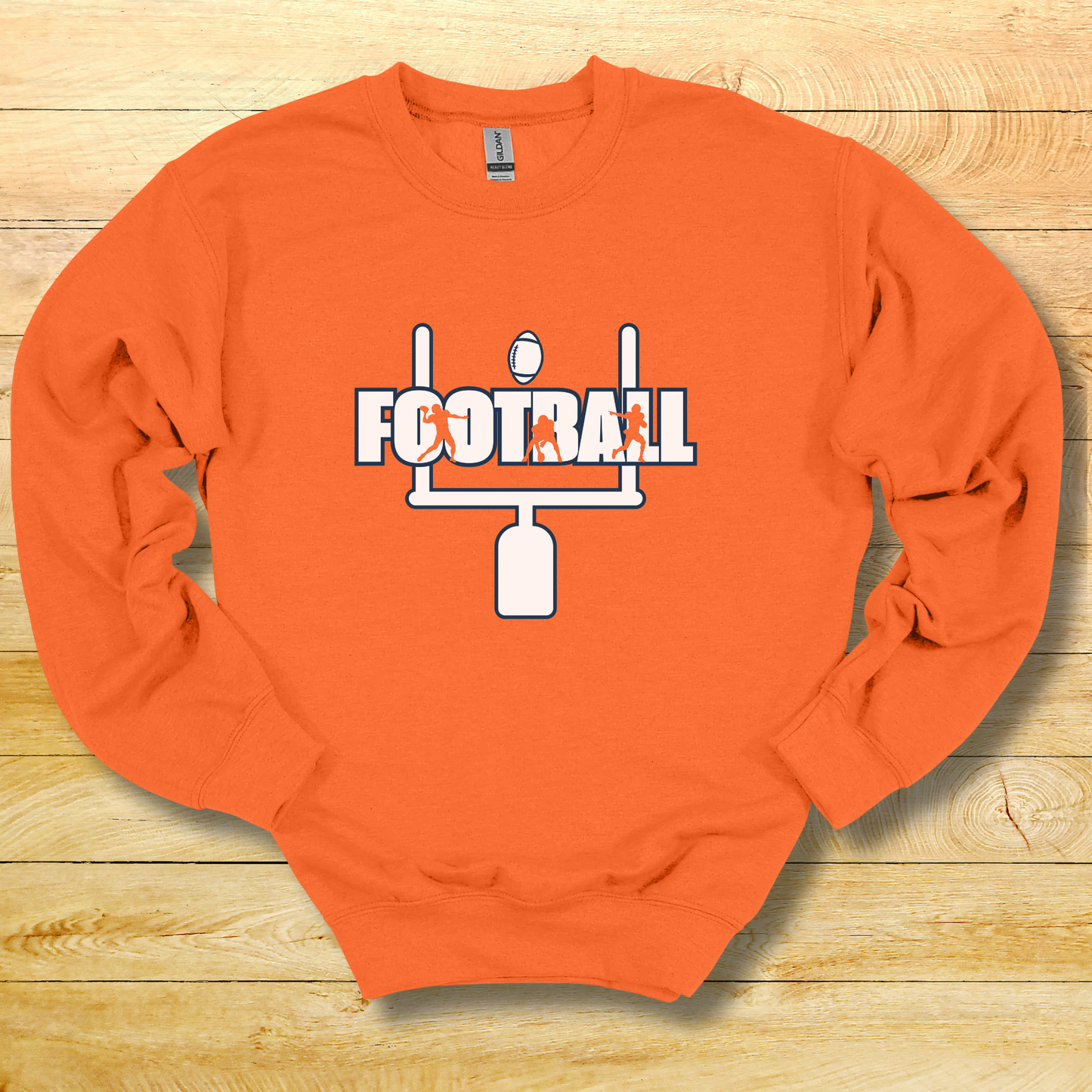 Orange sweatshirt with 'FOOTBALL' and goalpost design on a wooden surface
