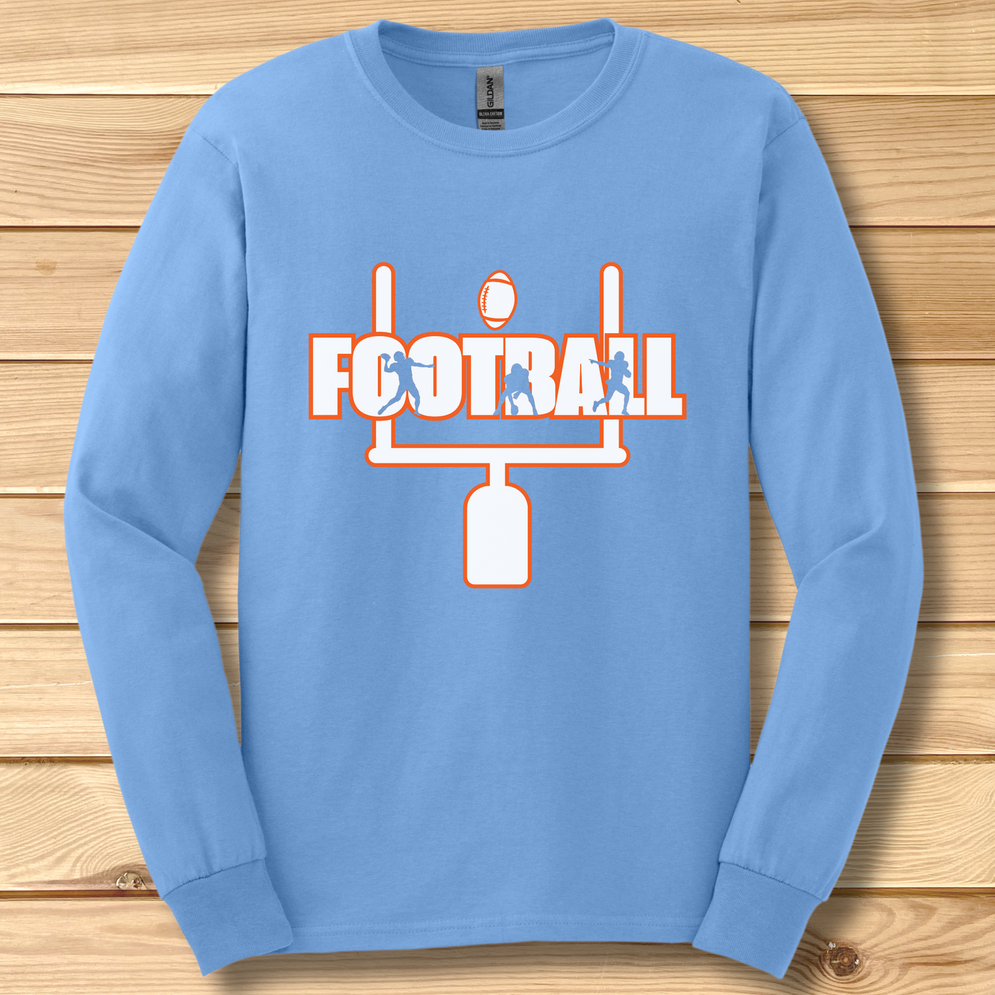 Blue long-sleeve shirt with football graphic on a wooden surface