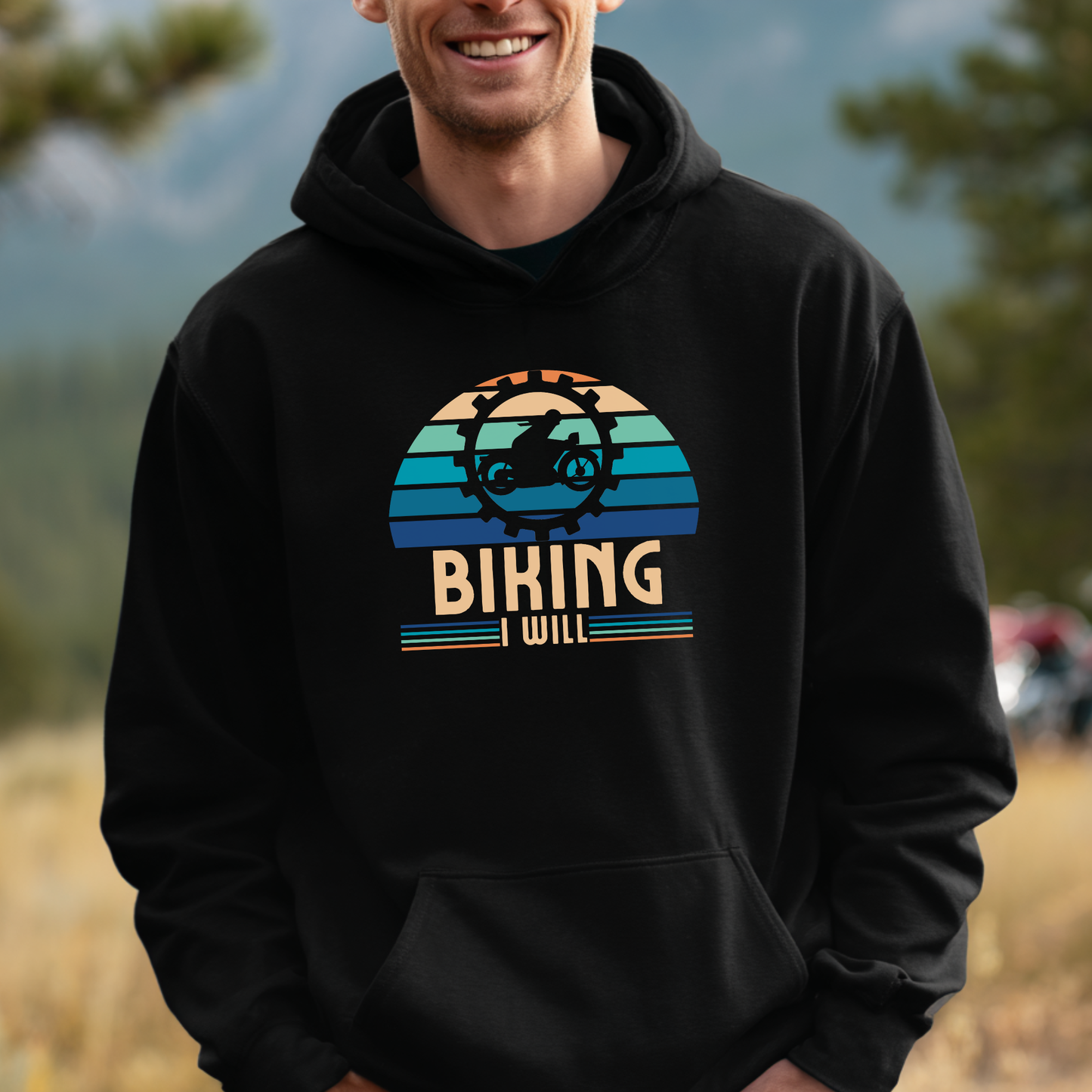 Person wearing a black hoodie with 'Biking Will' graphic design outdoors.