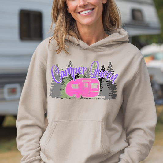 Woman wearing a beige hoodie with 'Camper Queen' design in front of an RV.