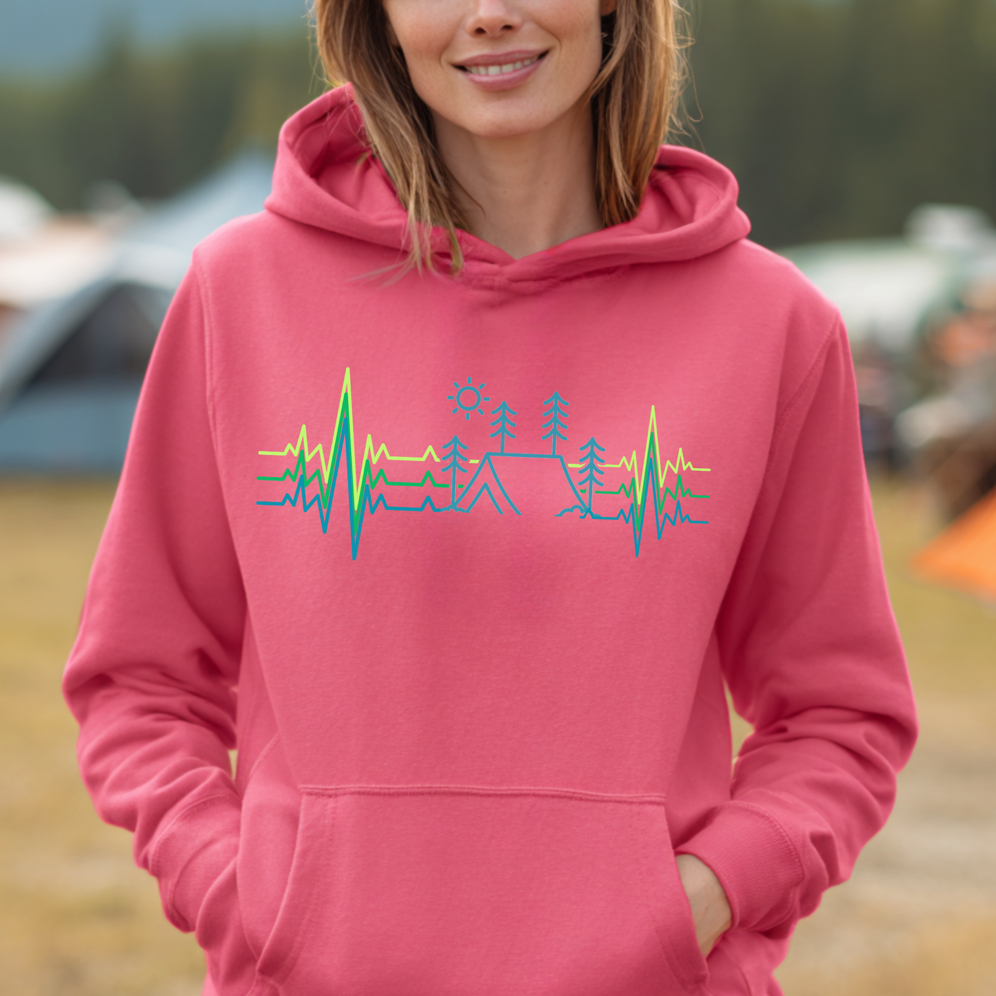 Person wearing a pink hoodie with a nature-themed design outdoors.
