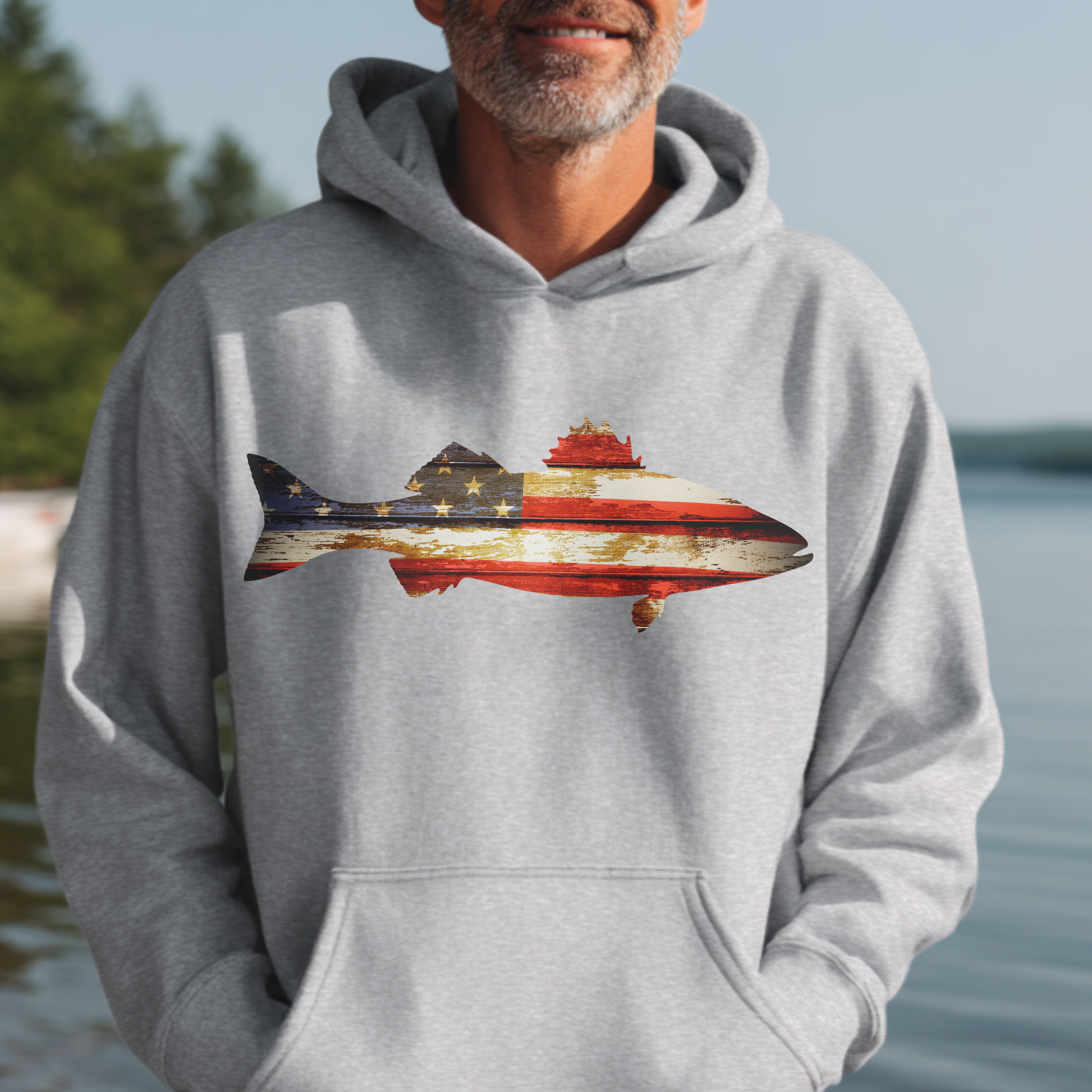 Person wearing a hoodie with a colorful submarine design outdoors by water